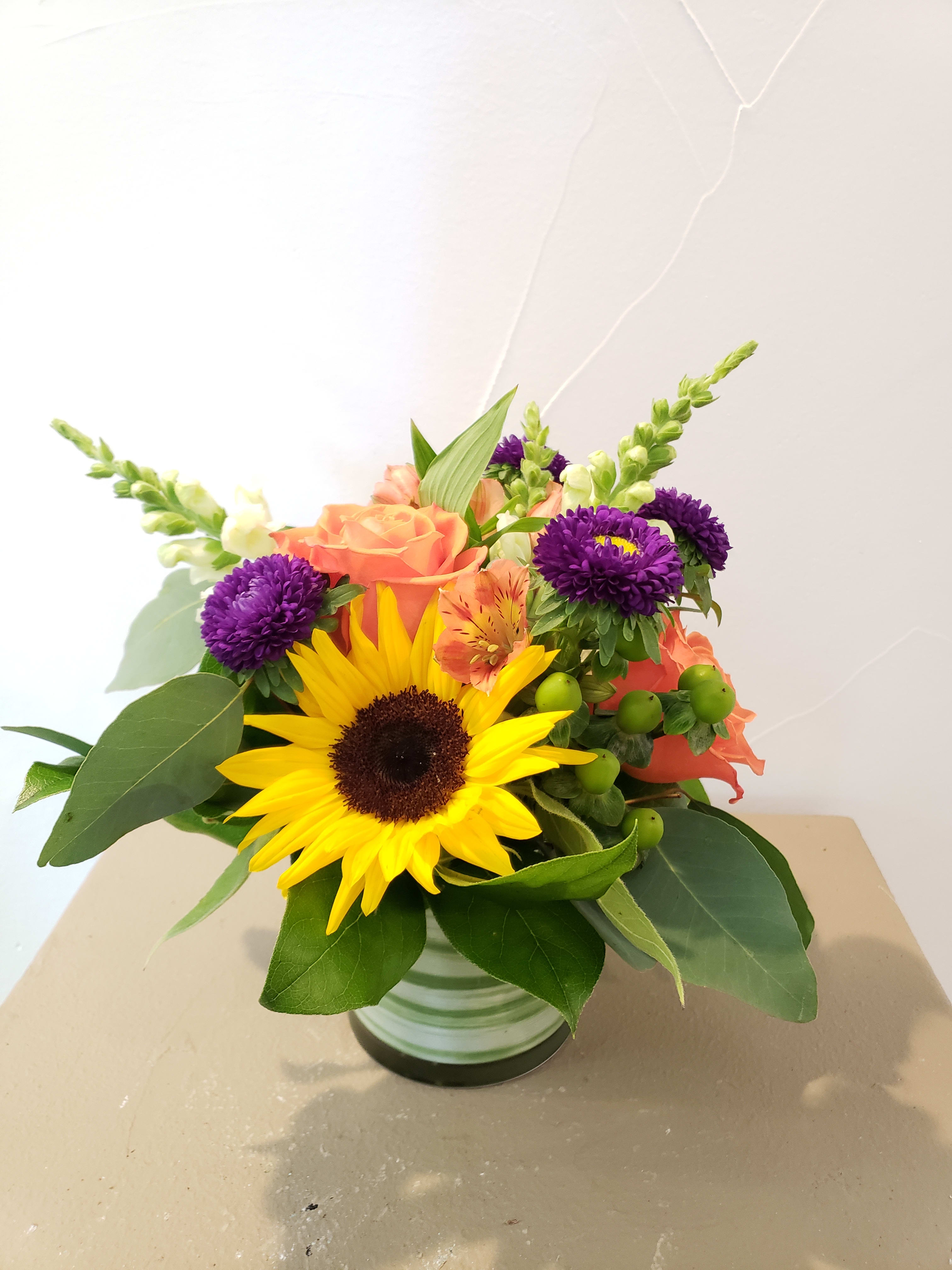 Autumn Bloom  - 4" cylinder vase with alstromeria, aster, sunflowers, roses and snap dragons. 
