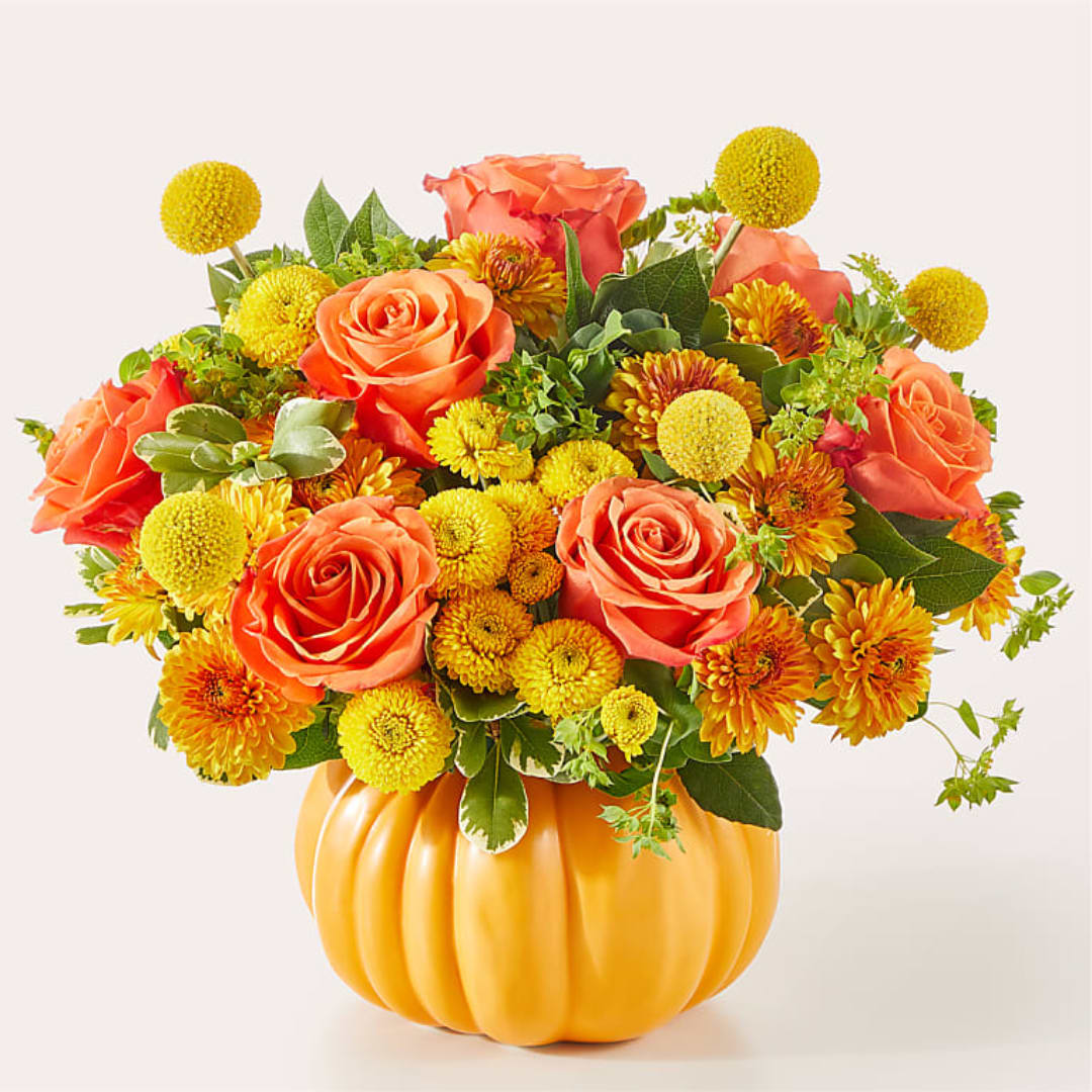 Orange roses and yellow mums arranged in a pumpkin-shaped vase