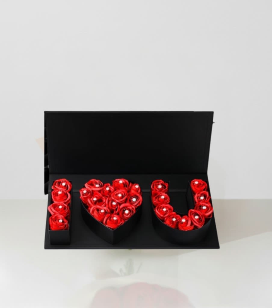 Red roses arranged in a black box to spell "I LOVE U"