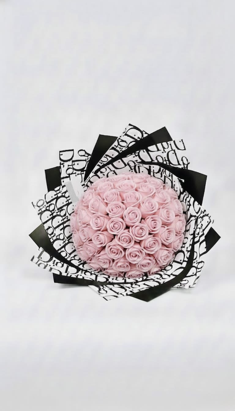 Round bouquet of pale pink roses wrapped in black-and-white paper