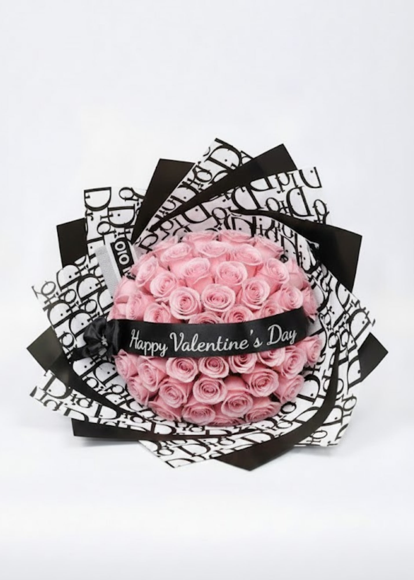 Pink rose bouquet wrapped in black-and-white paper with a Valentine ribbon