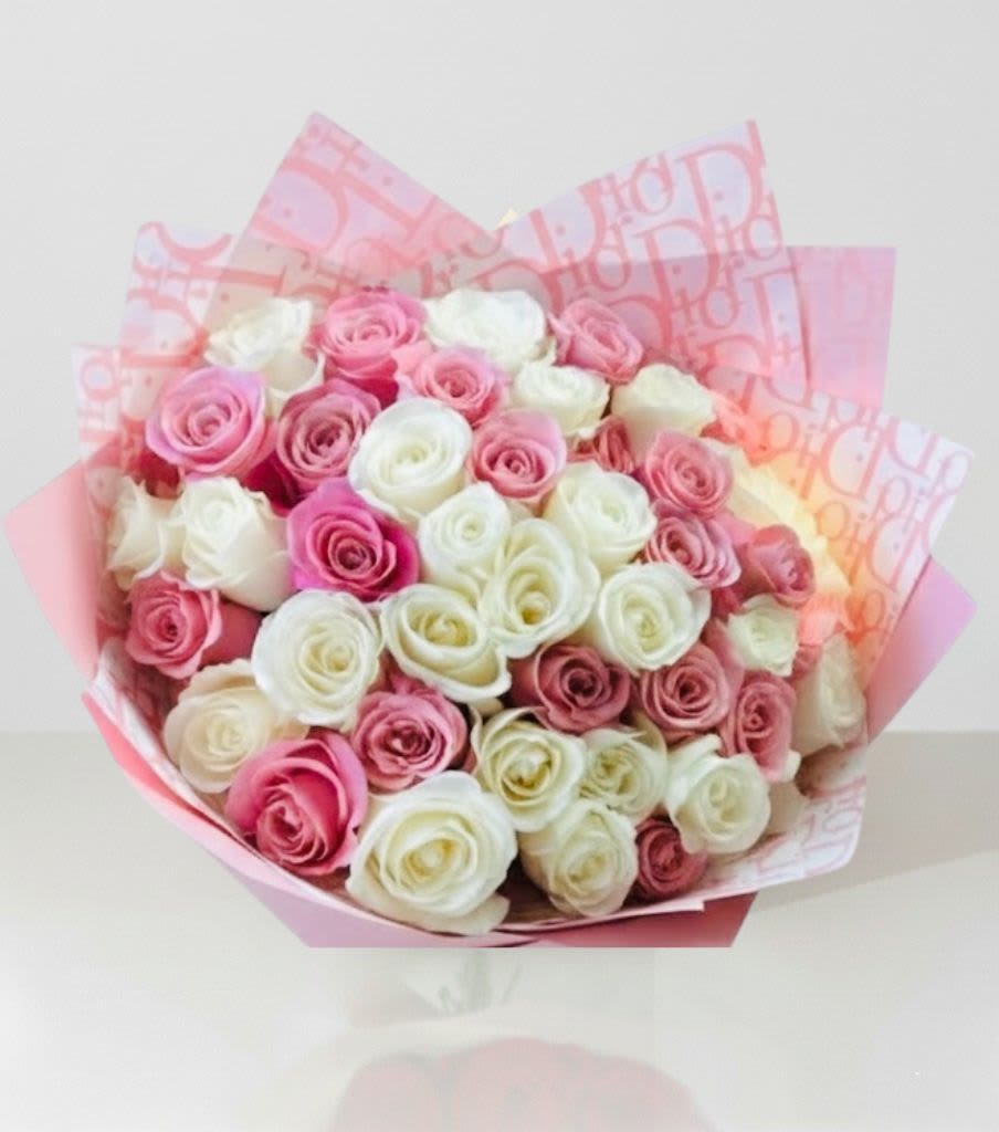Bouquet of pink and white roses wrapped in pink paper