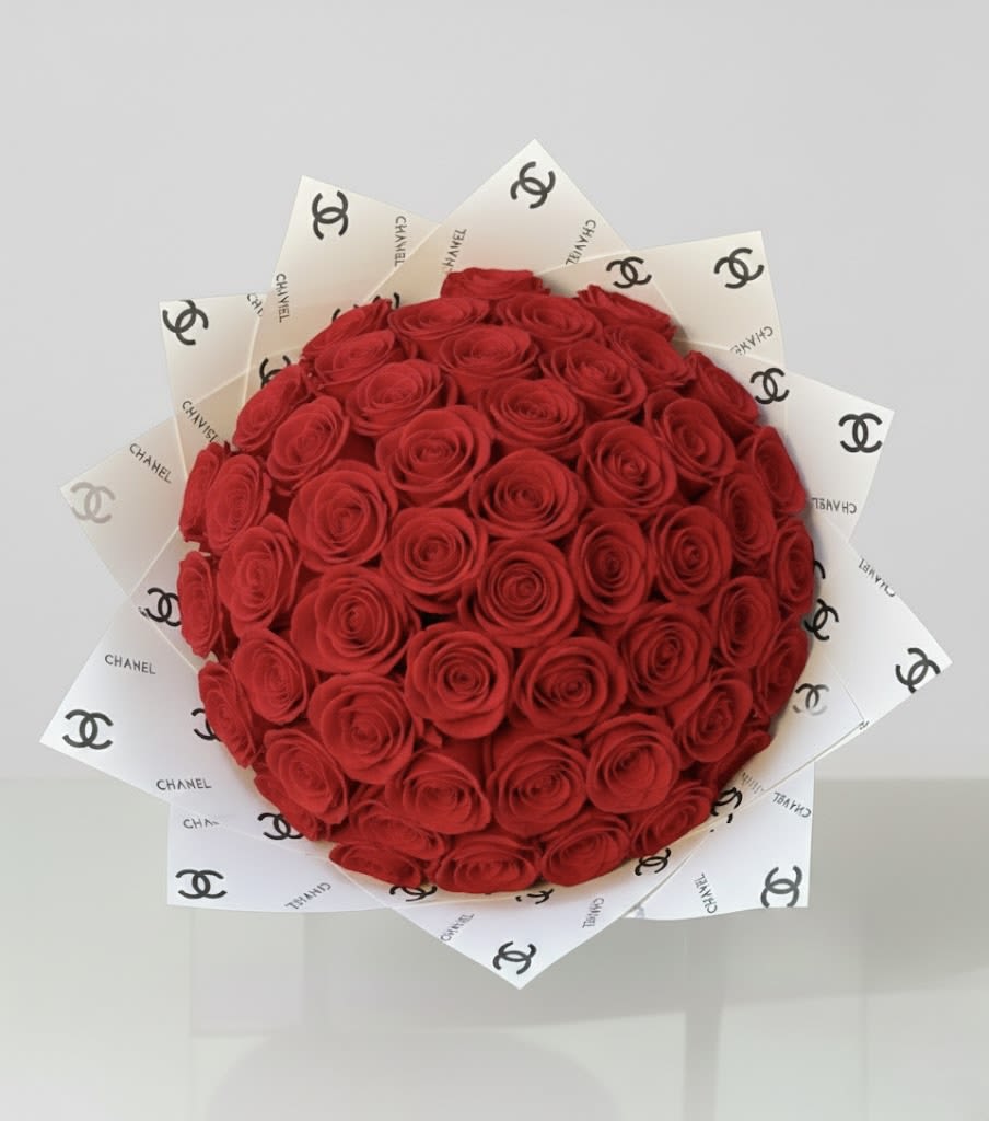 Round bouquet of red roses wrapped in white Chanel paper