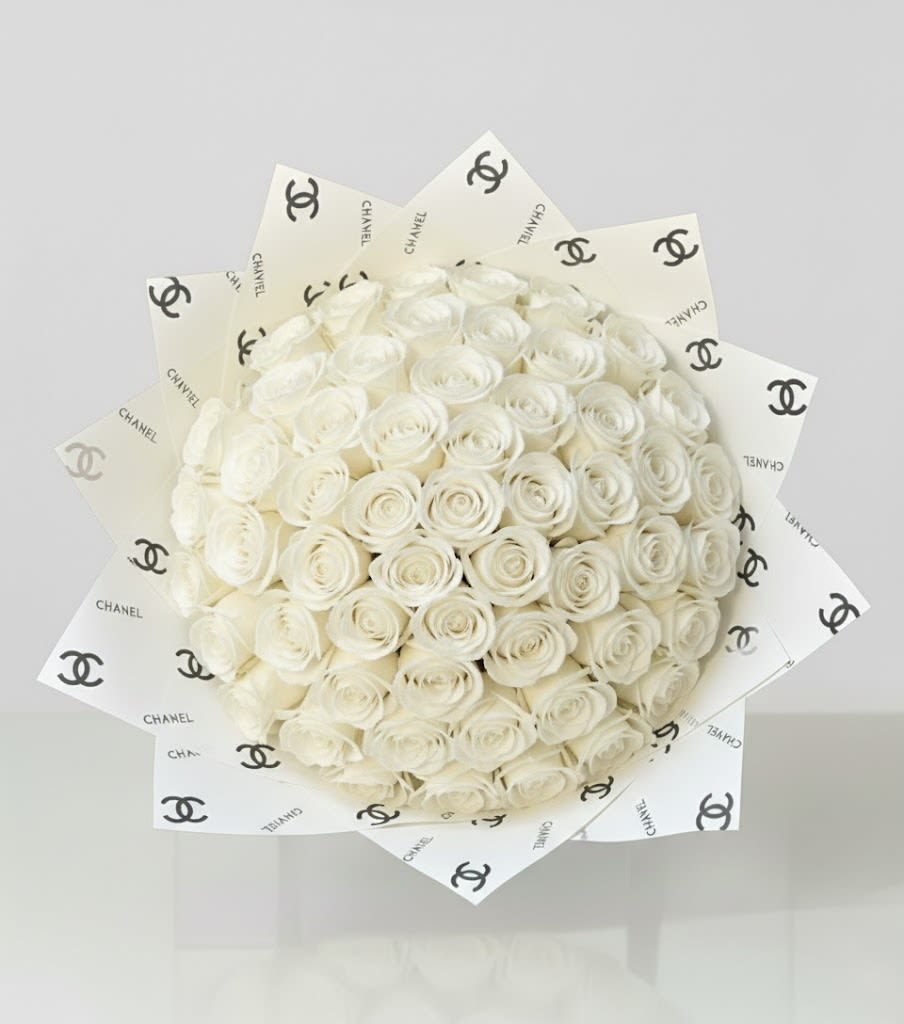 Bouquet of white roses wrapped in Chanel-logo paper