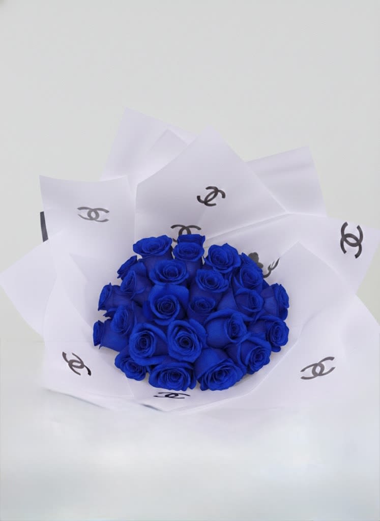 Bouquet of vivid blue roses wrapped in white paper