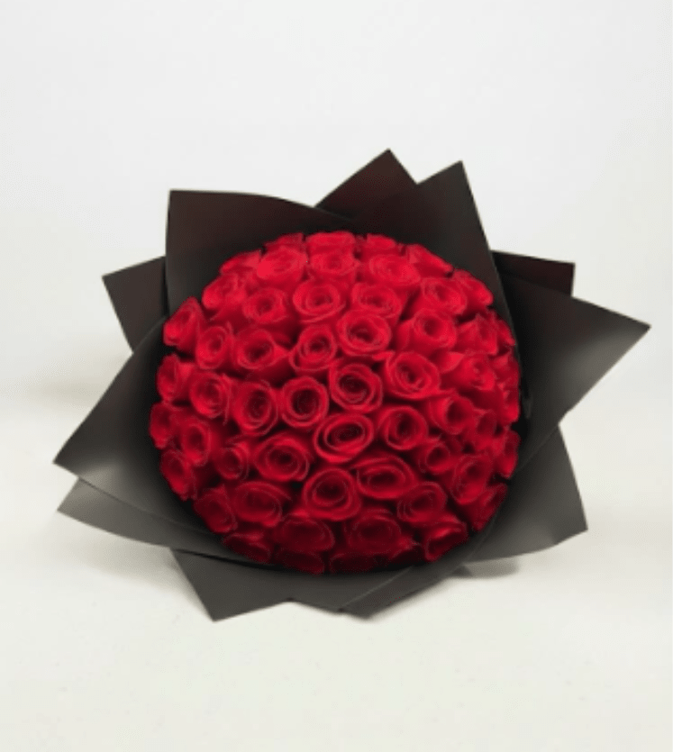 Round bouquet of red roses wrapped in black paper