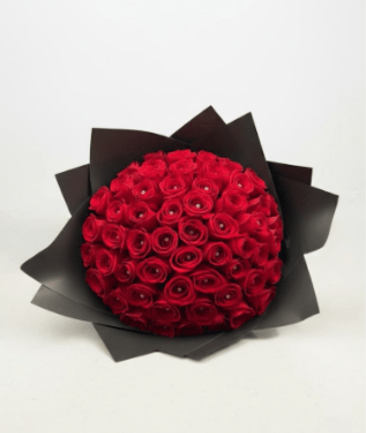Round bouquet of red roses wrapped in black paper