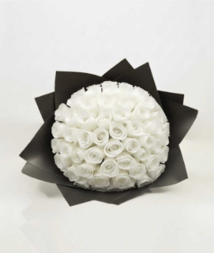 Round bouquet of white roses wrapped in black paper