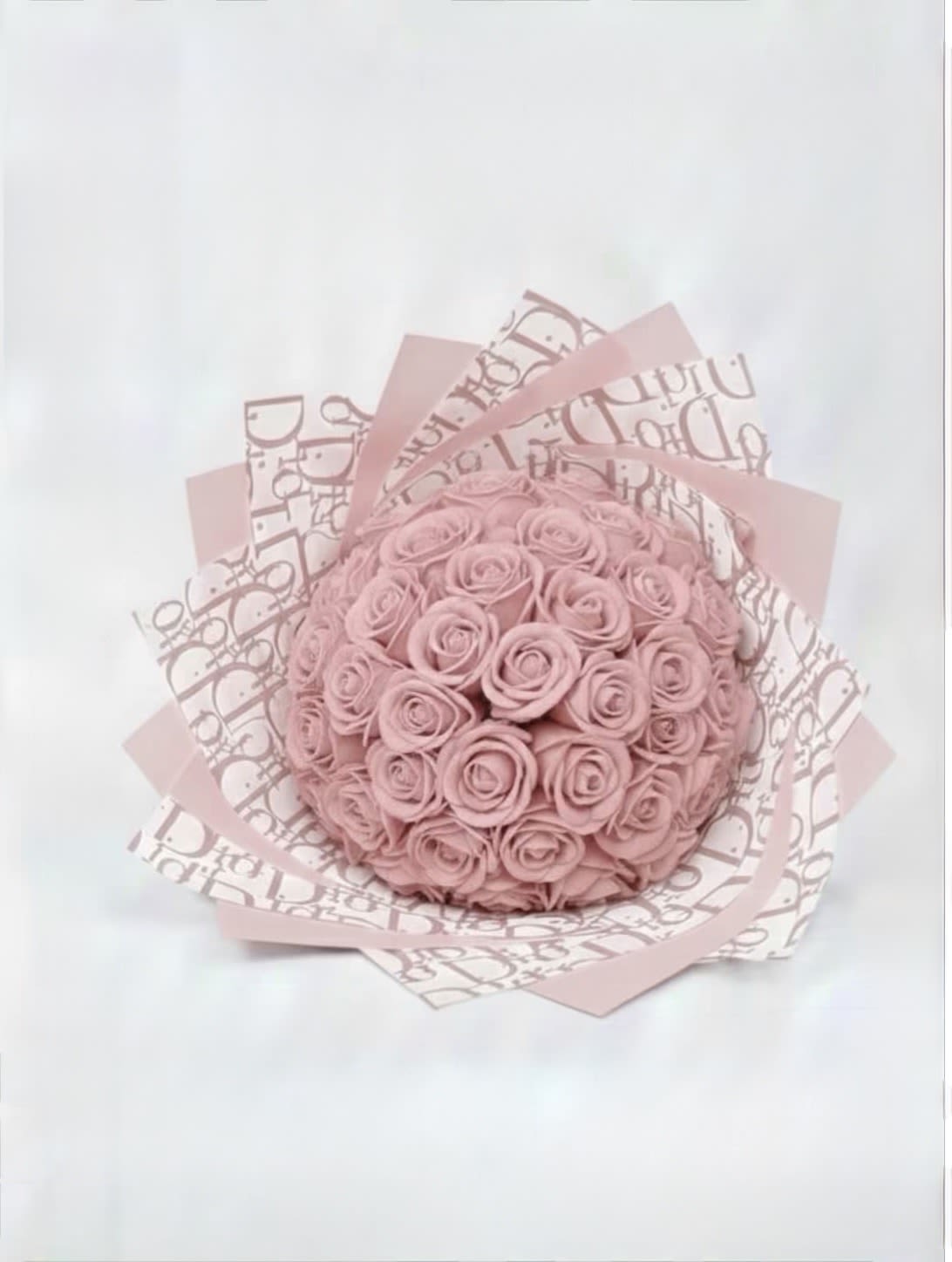 Round bouquet of pink roses wrapped in patterned pink paper