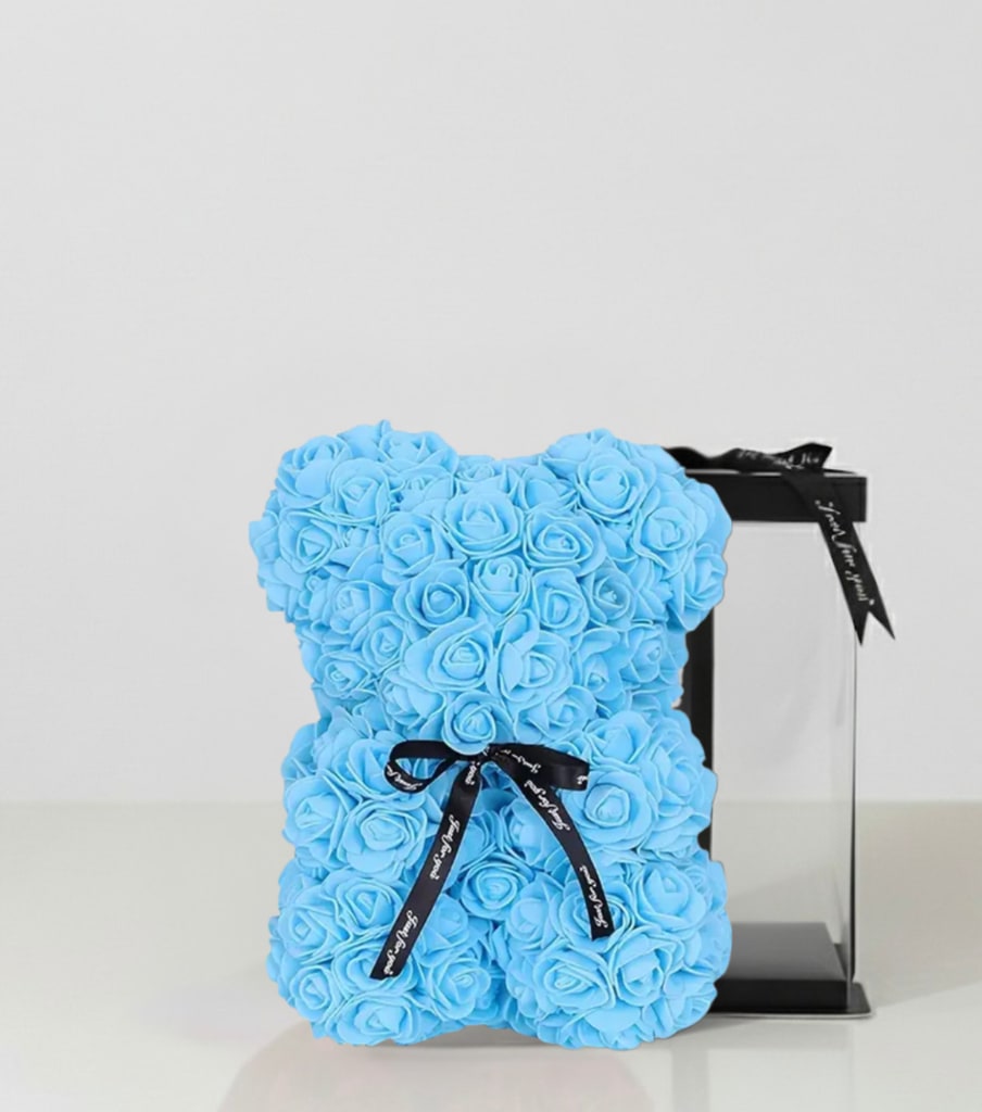 Blue rose-shaped teddy bear with a black ribbon and gift box