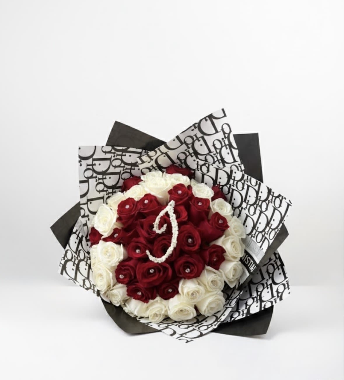 Bouquet of red and white roses wrapped in black-and-white patterned paper