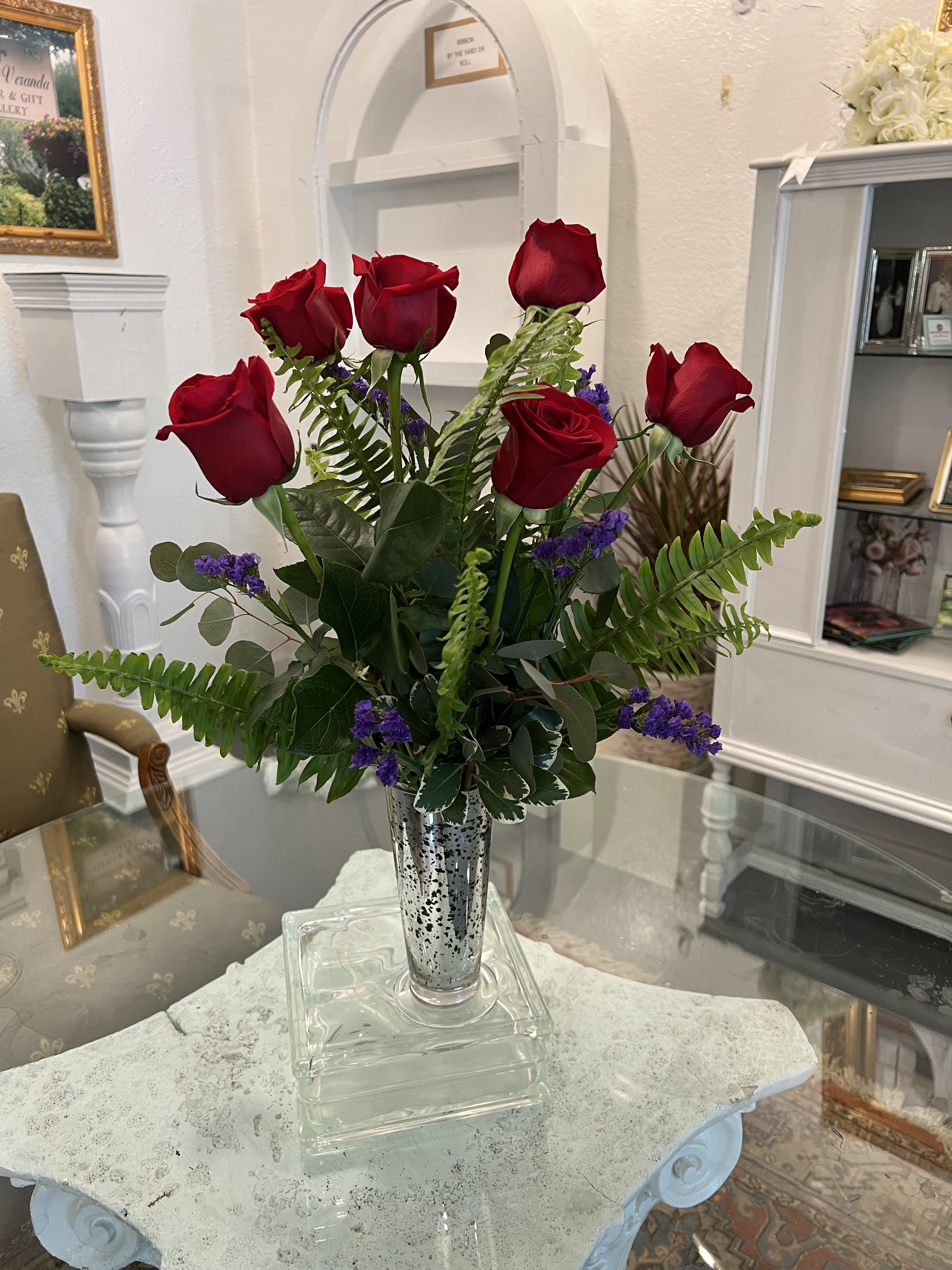 Bouquet of red roses in a silver vase with purple filler flowers