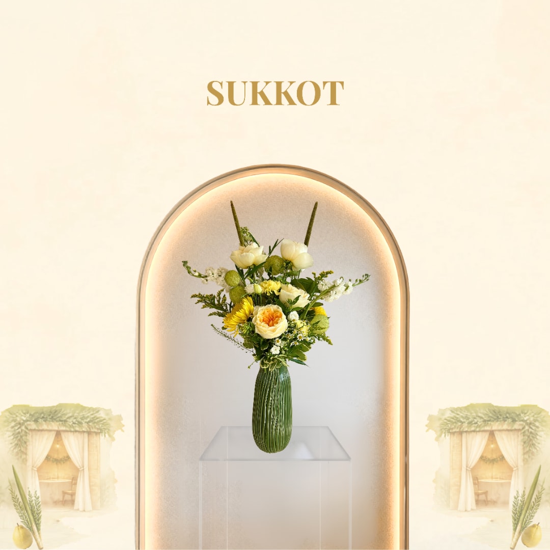 Yellow and white floral arrangement in a green vase with Sukkot text above