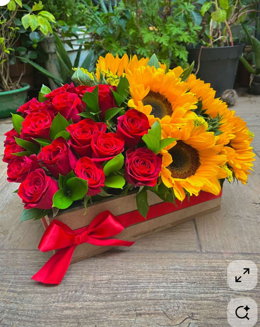 Red roses and yellow sunflowers in a rectangular box with a red ribbon