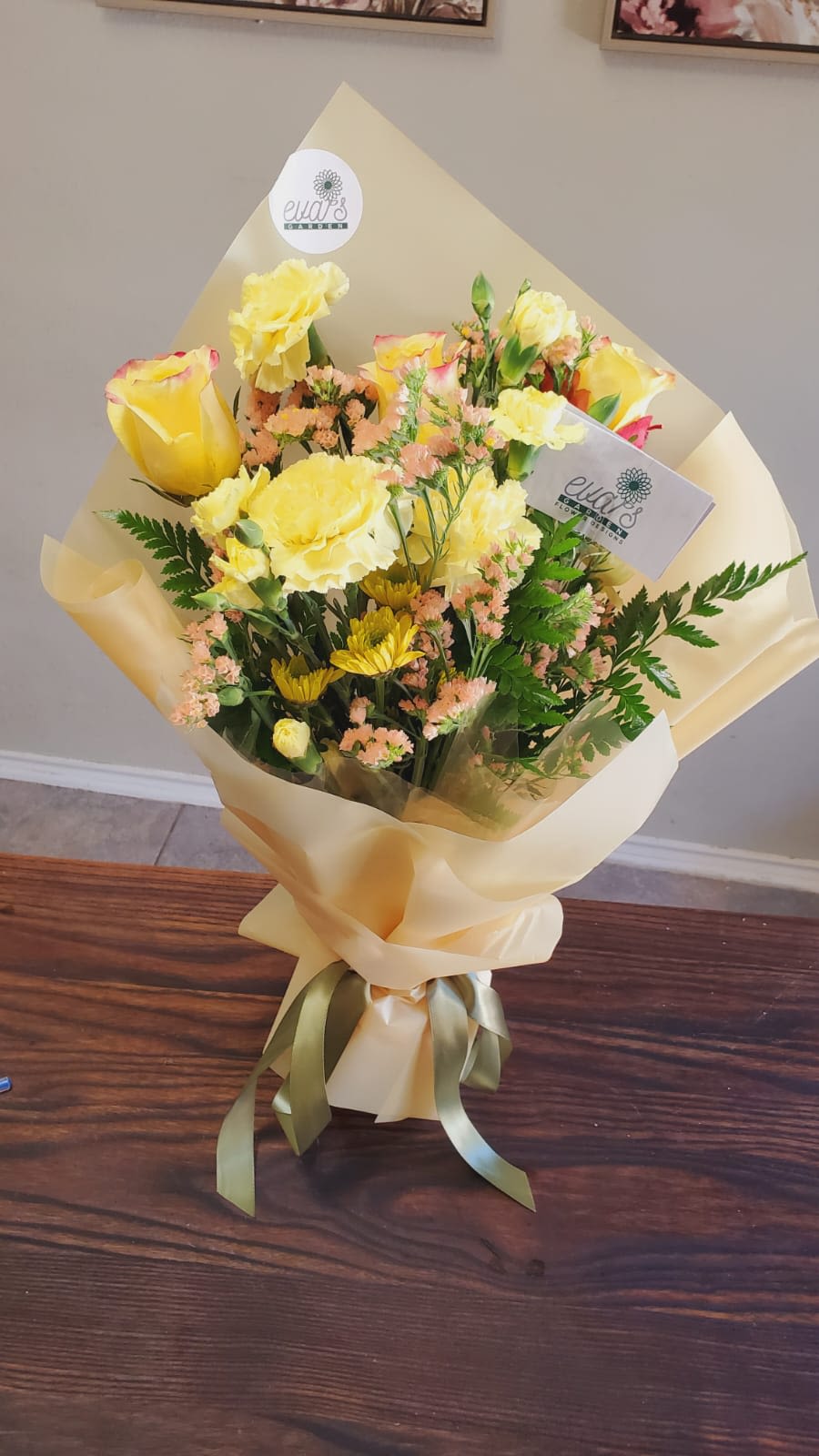 Bouquet of yellow roses and mixed blooms wrapped in cream paper