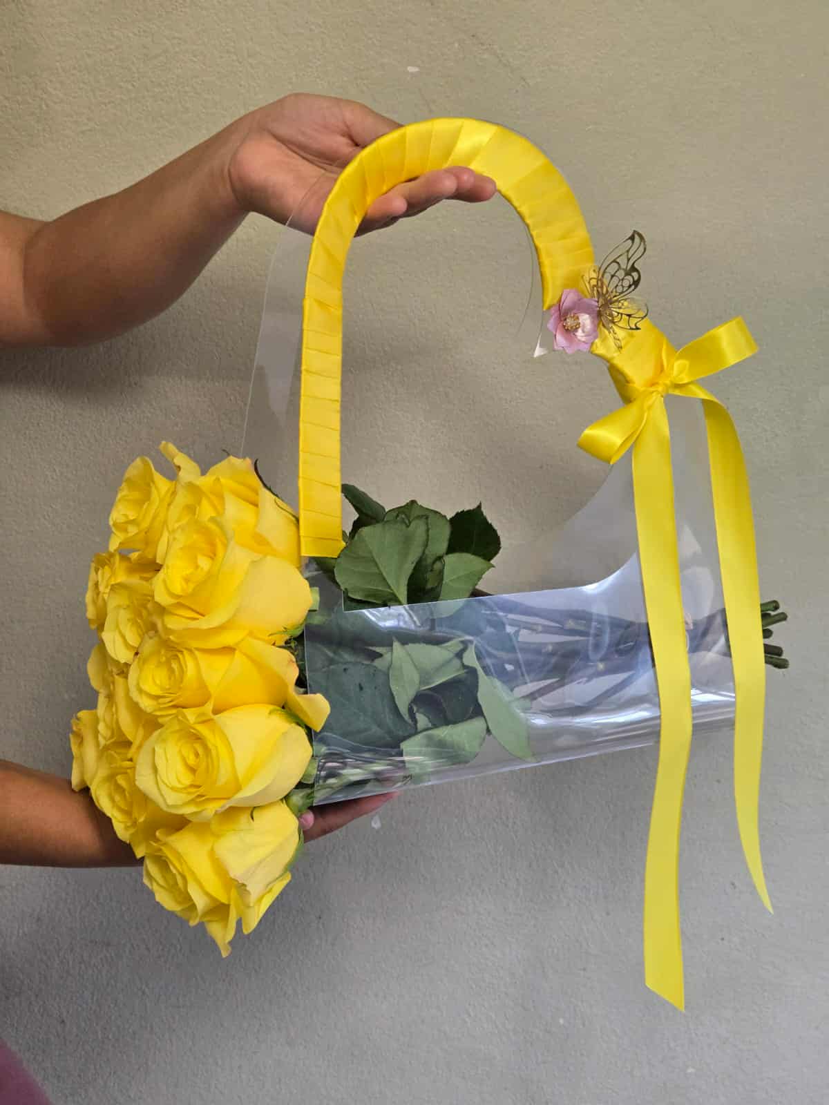Yellow rose bouquet in a clear handbag-style wrap with ribbon