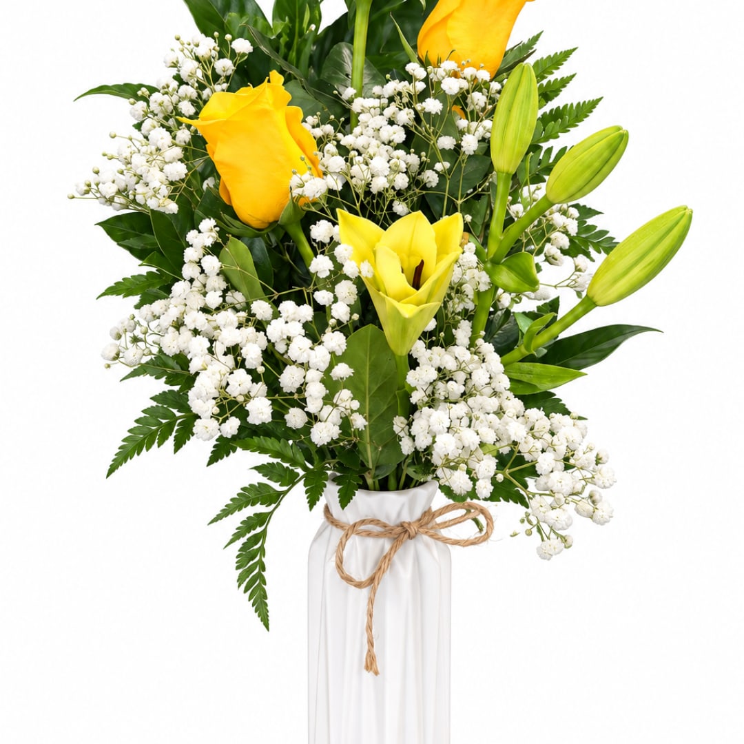 Yellow roses and lilies in a white vase with baby's breath