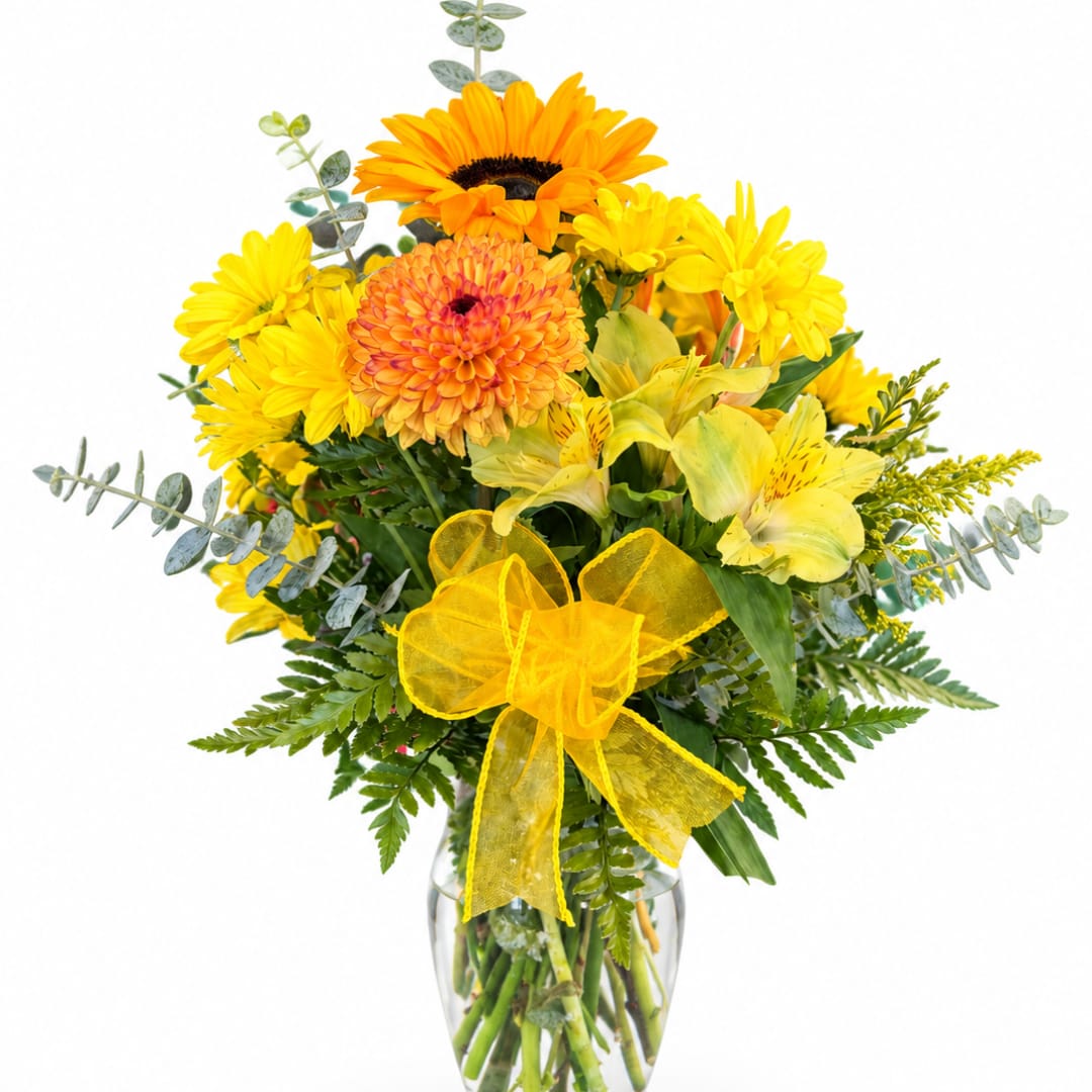 Yellow and orange mixed bouquet in a clear glass vase with a yellow ribbon