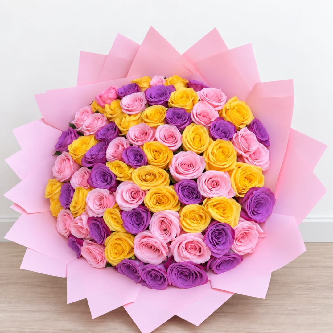 Bouquet of pink, purple, and yellow roses wrapped in pink paper