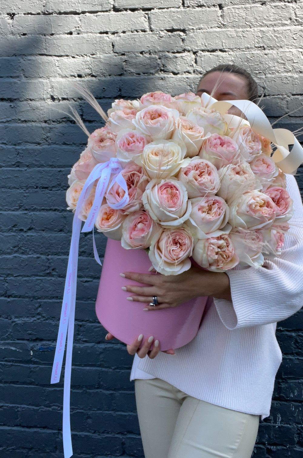 Large bouquet of blush and cream roses in a pink hat box