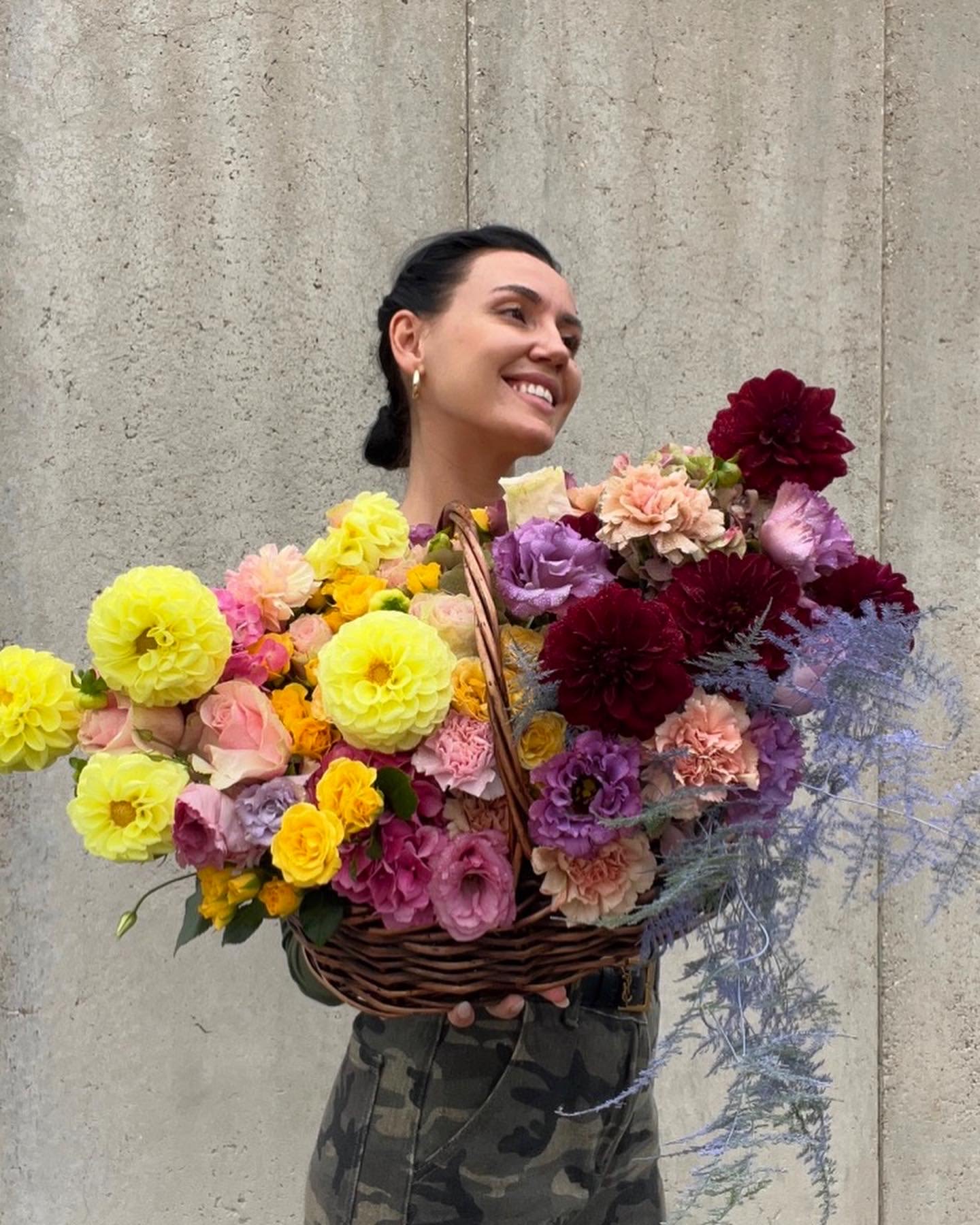Woman holding a large basket of colorful flowers
