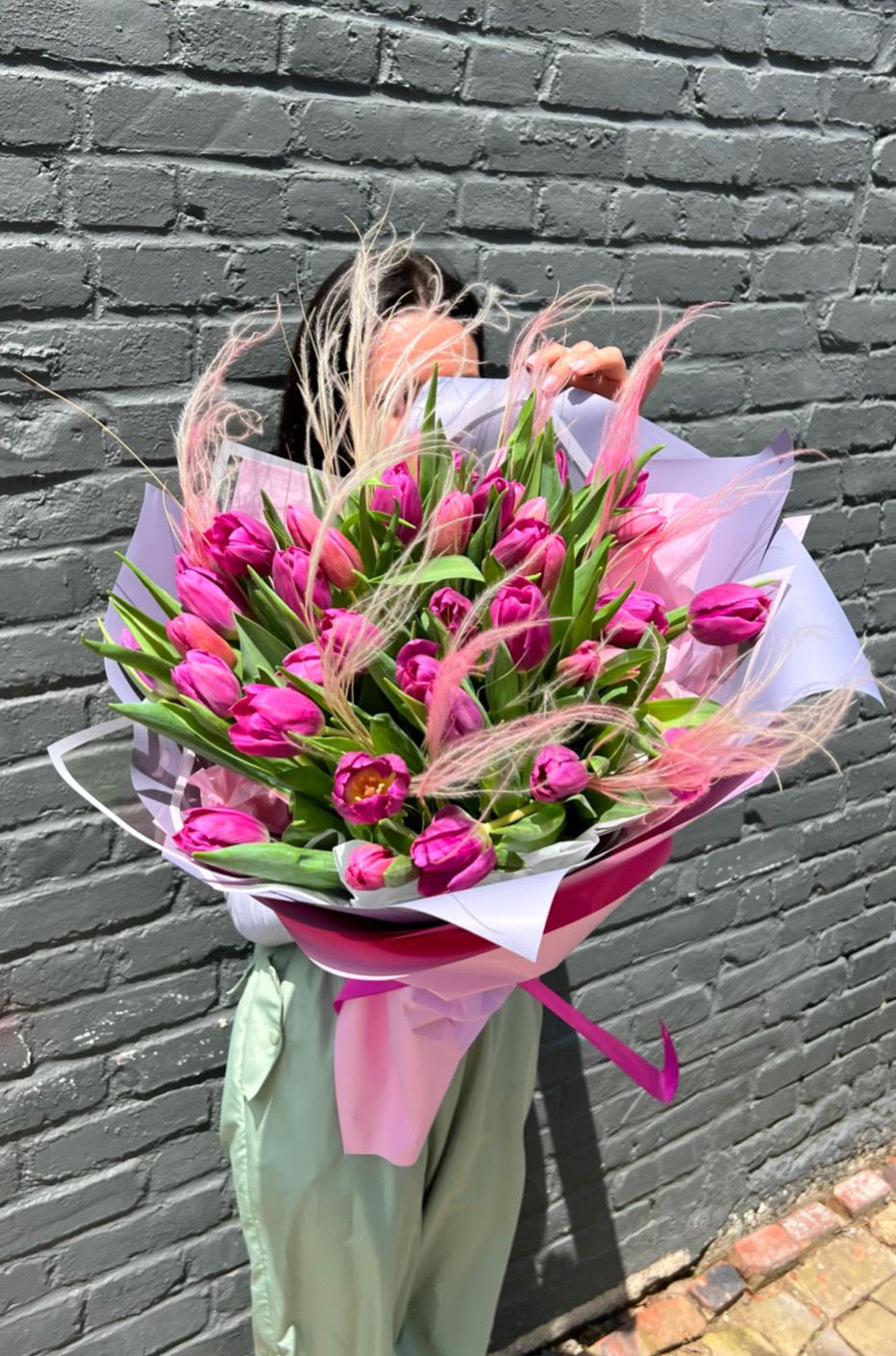 Bouquet of bright pink tulips wrapped in pastel paper