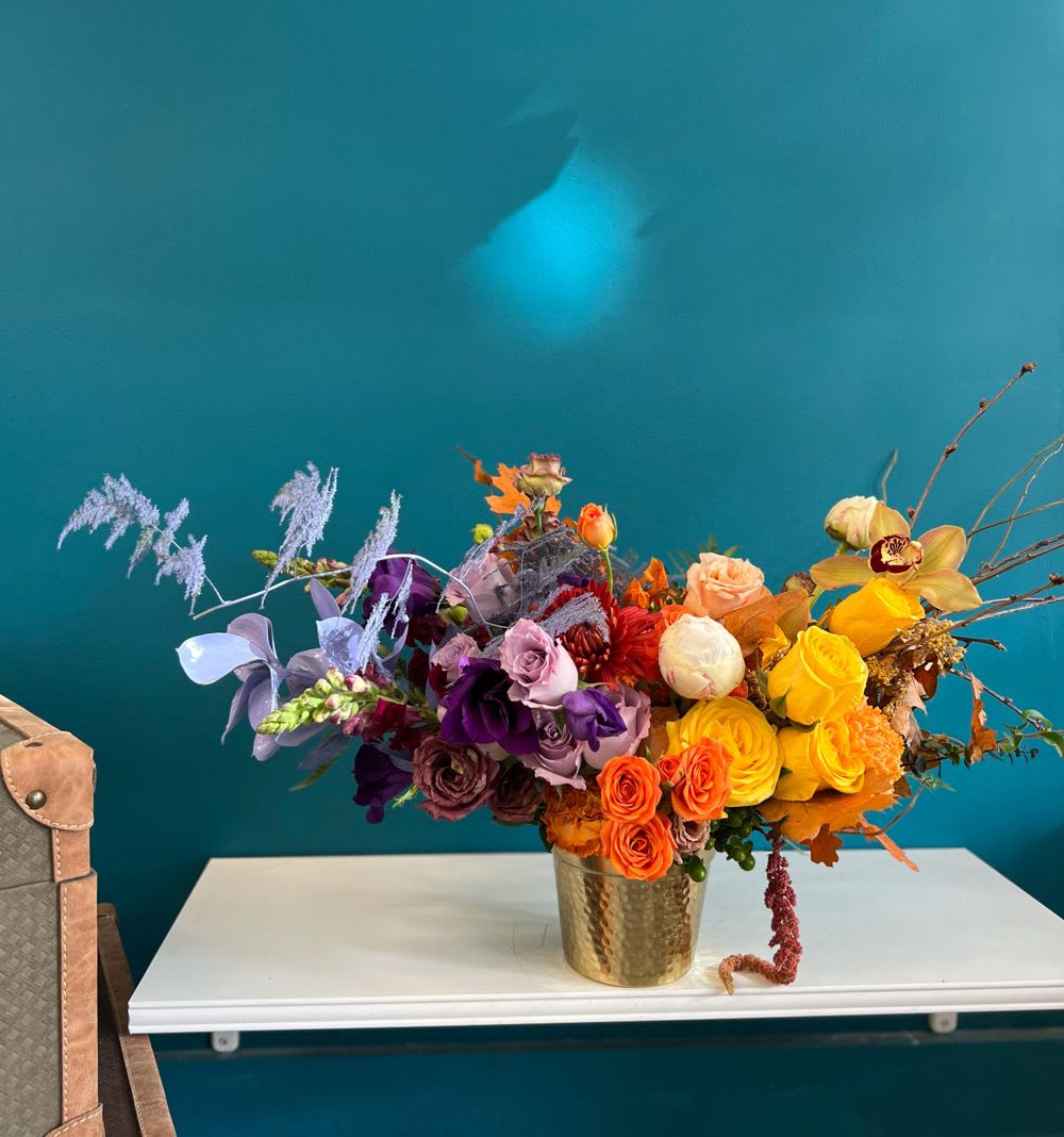Mixed bouquet of roses and orchids in a gold vase