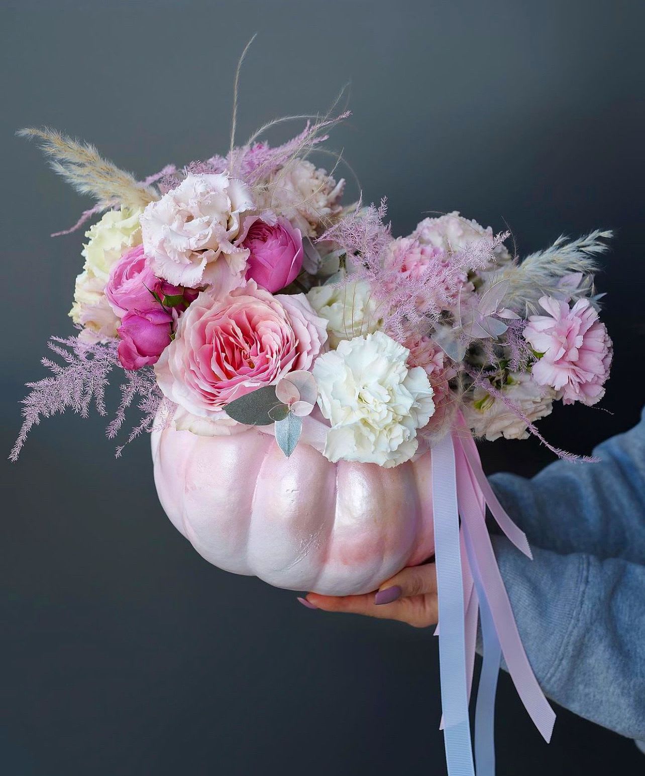 Pink and white floral arrangement in a painted pumpkin container