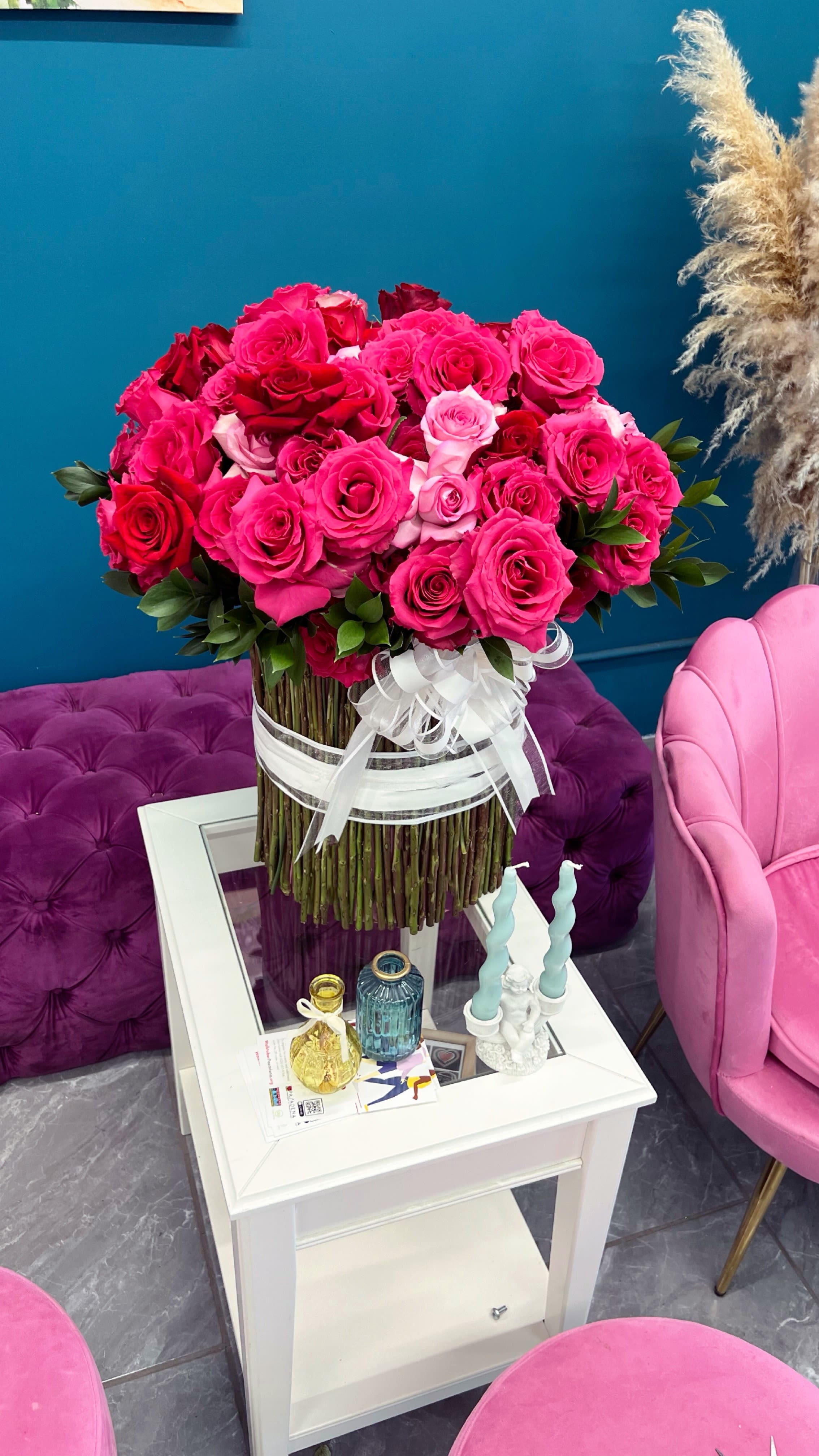 Large bouquet of pink and red roses tied with a white ribbon