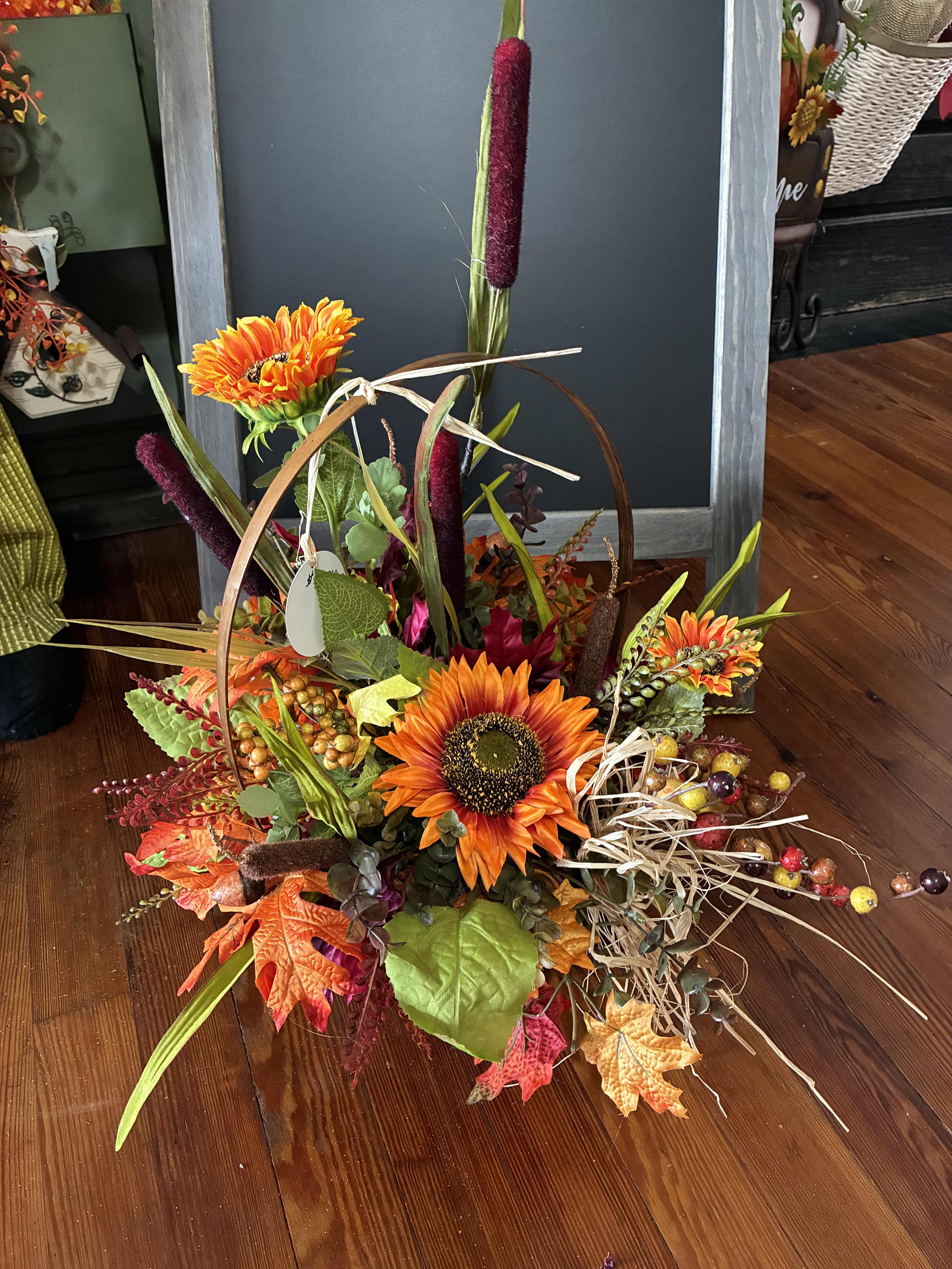 Autumn floral basket with orange sunflowers and decorative leaves