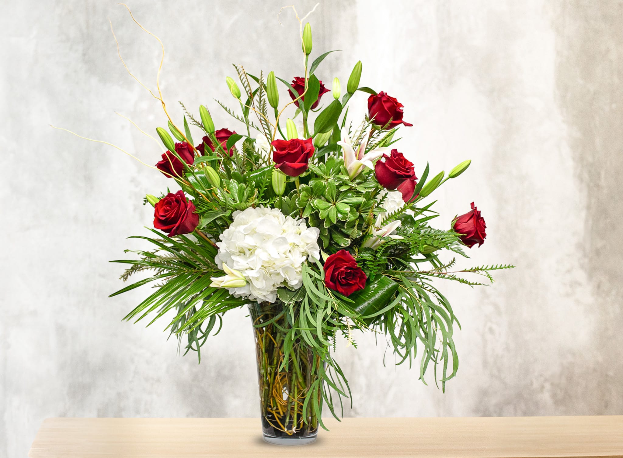 Red roses and white hydrangea in a glass vase