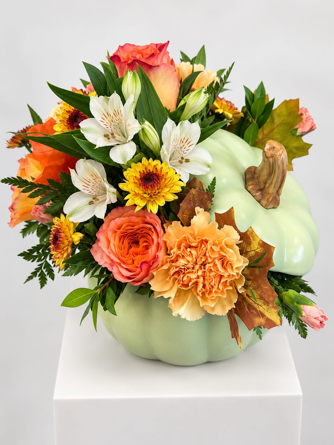 Pumpkin-shaped floral arrangement with orange, white, and yellow blooms