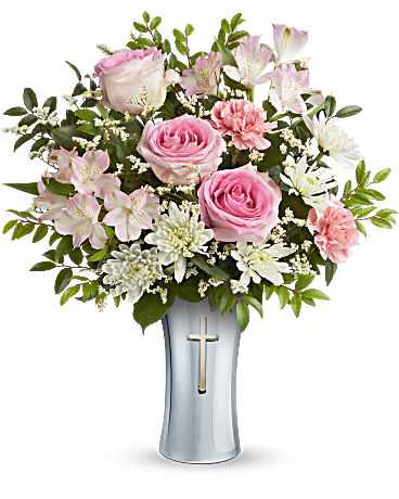 Pink roses and white flowers arranged in a silver vase with a cross