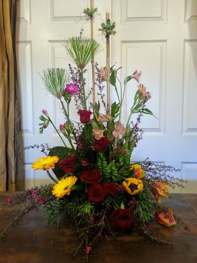 Tall mixed floral arrangement with red roses and yellow gerbera daisies