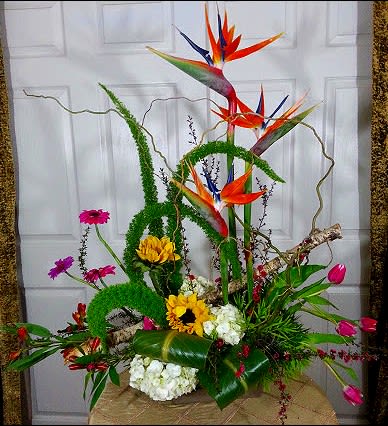 Tall tropical floral arrangement with bird-of-paradise and sunflowers