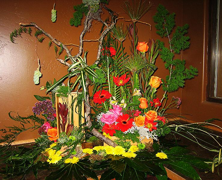 Large tropical floral arrangement with bright mixed blooms and branches
