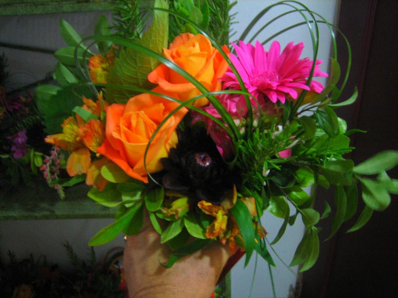 Bouquet of orange roses and pink gerbera daisies with greenery