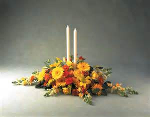 Low floral centerpiece with two white taper candles