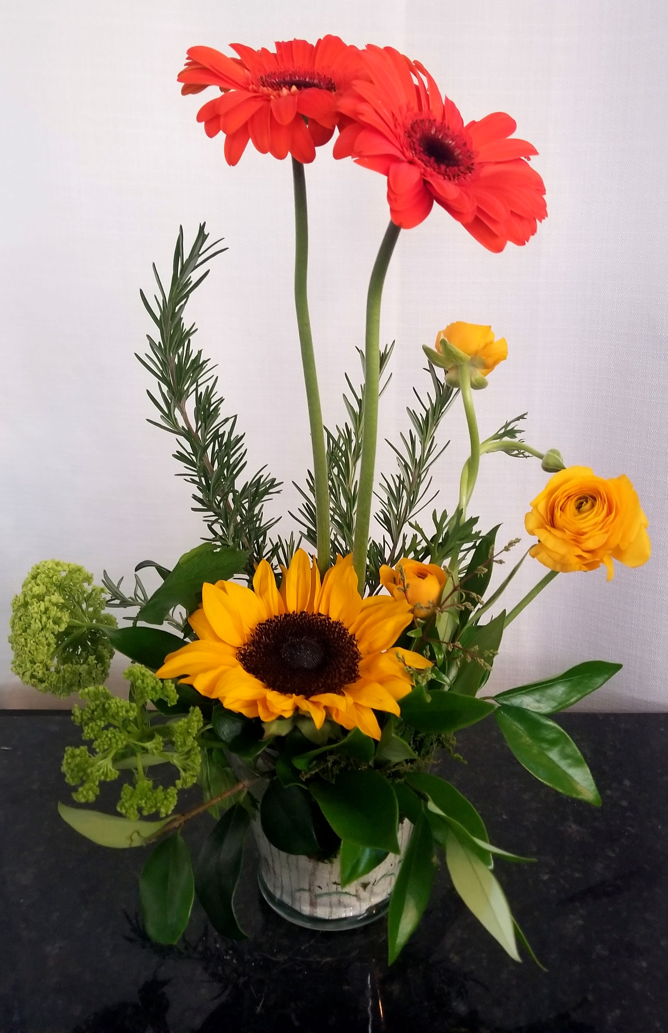 Mixed bouquet with red and yellow gerbera daisies in a glass vase