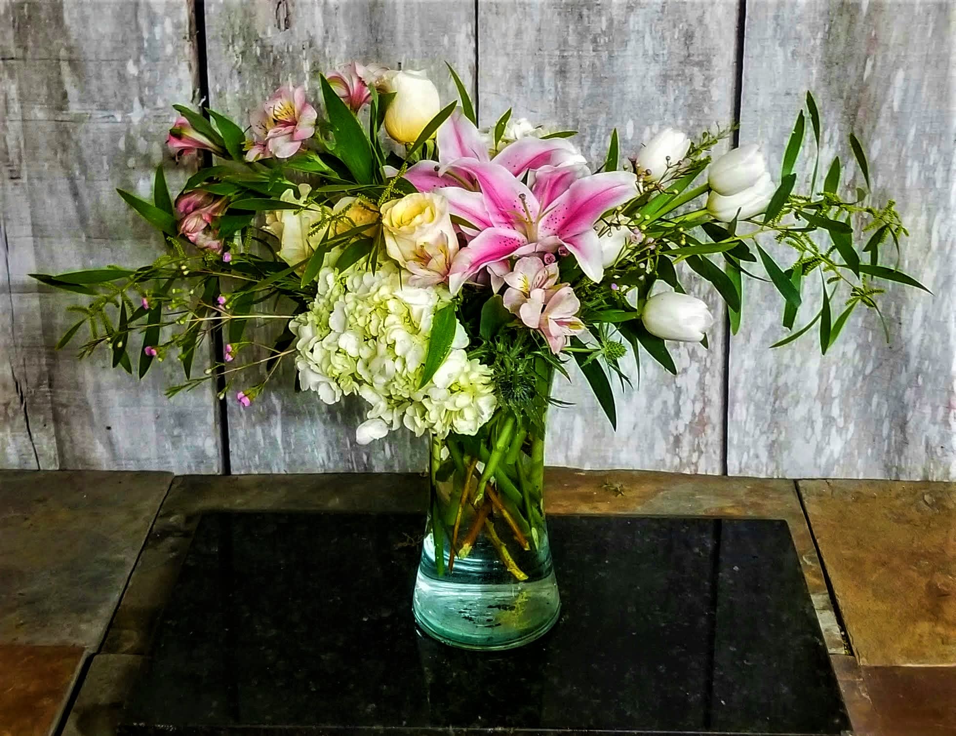 Pink lilies and white roses in a glass vase