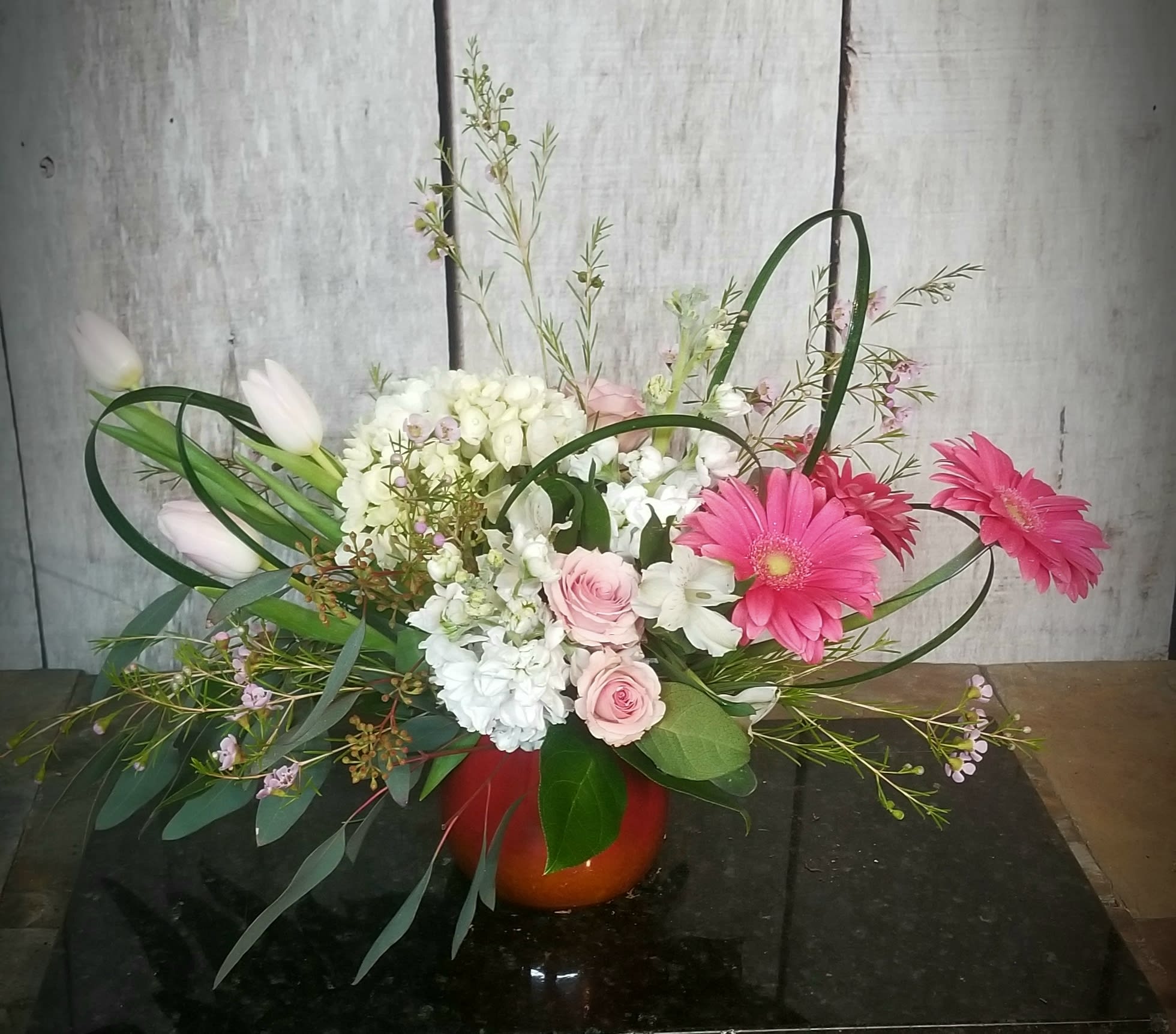 Pink gerberas and roses in a red vase with white tulips