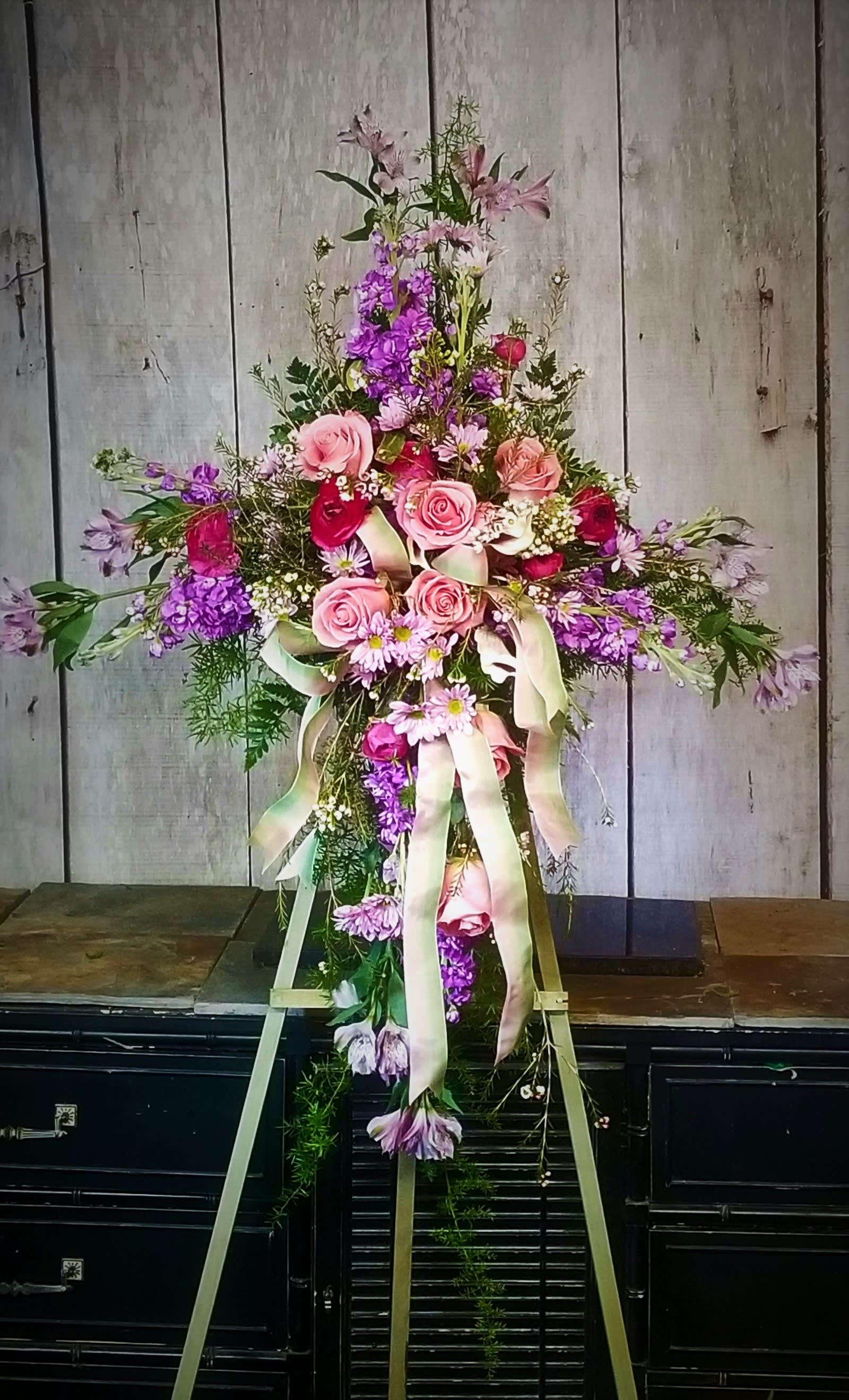 Tall floral spray with pink and purple flowers on a stand