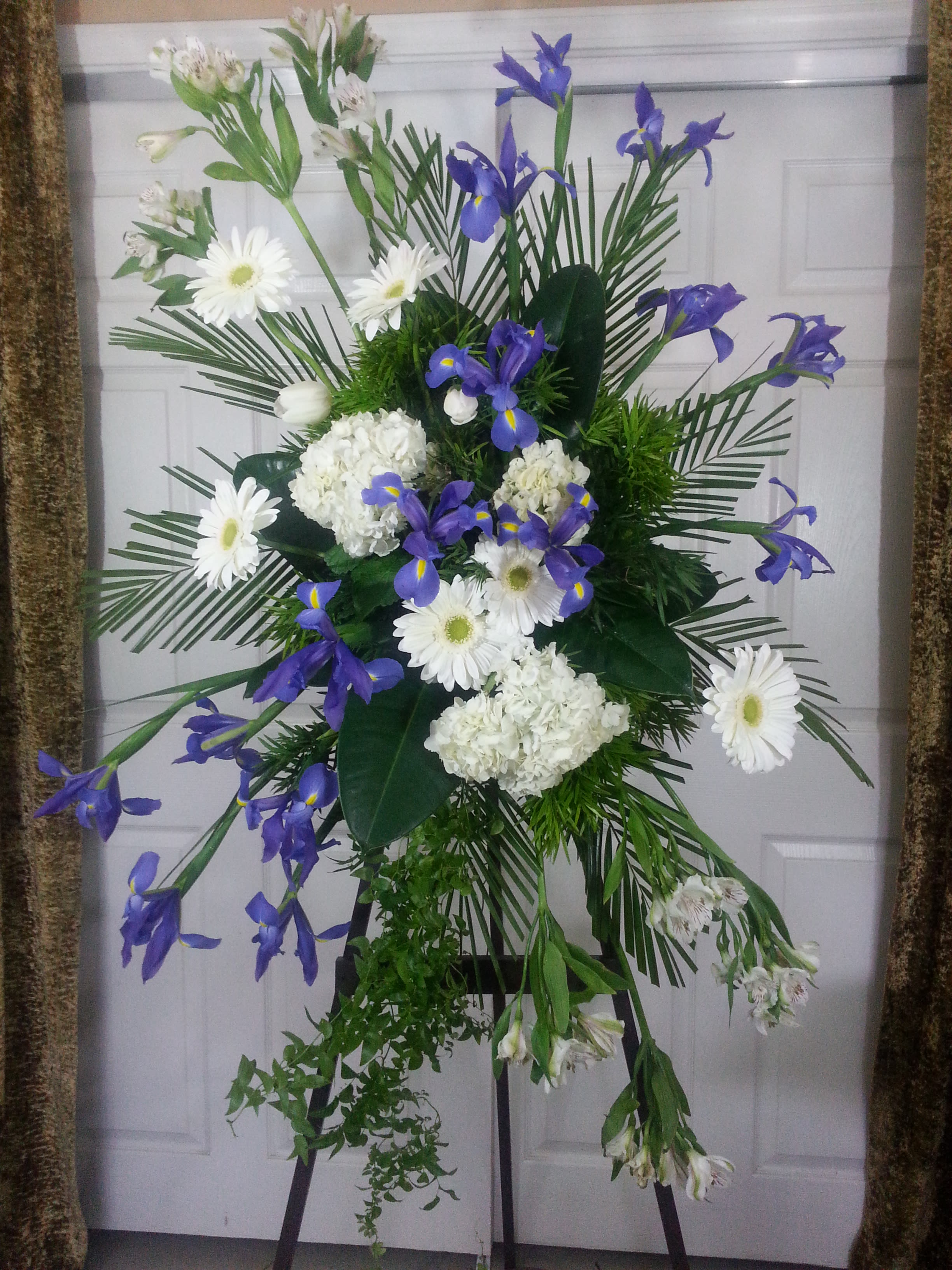 Standing floral spray with white daisies, hydrangeas, and purple irises