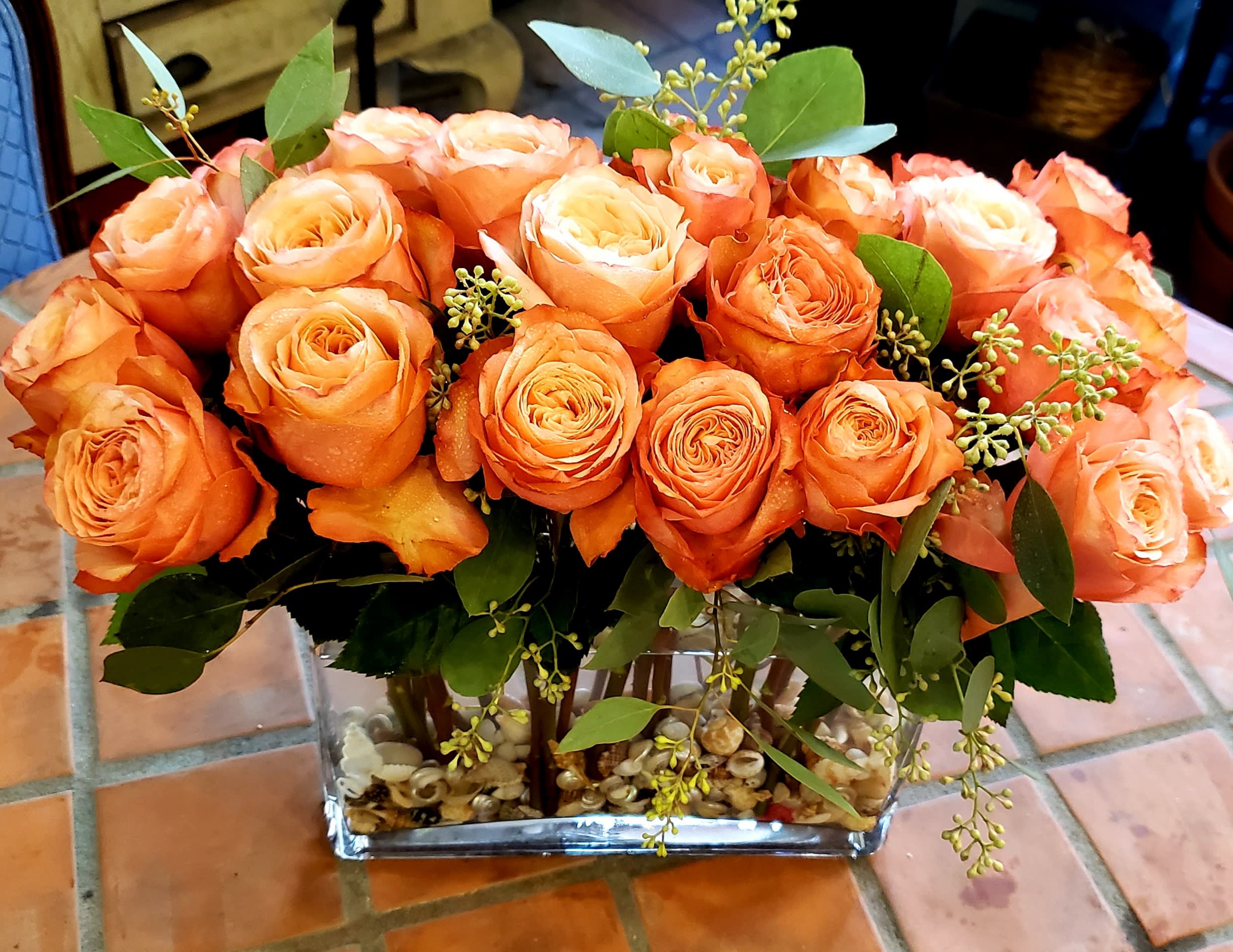 Orange roses arranged in a clear rectangular vase