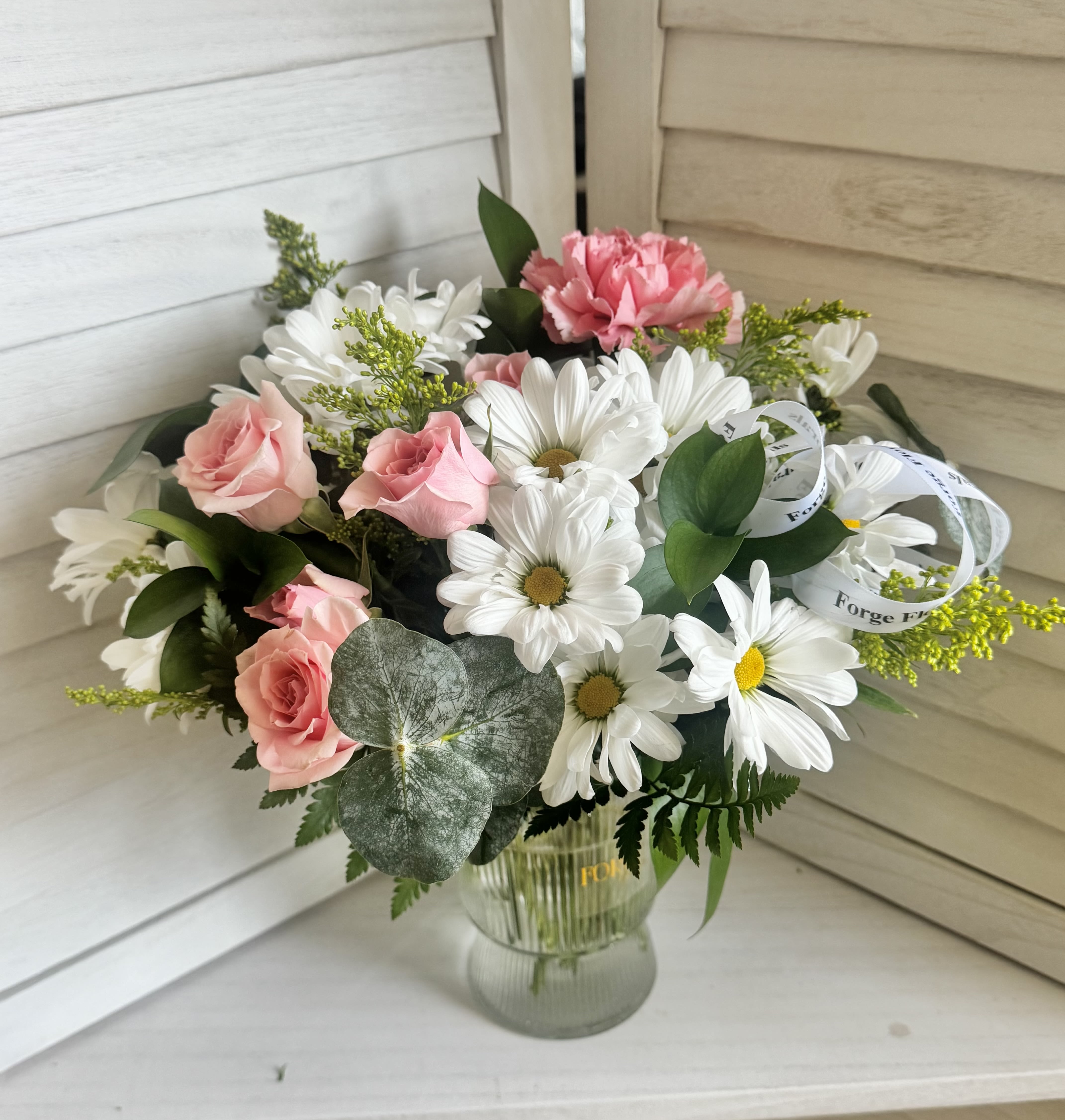 Sweet Daisy vase- Daisy,mini rose, Eucaliptus, solidago - A charming arrangement of fresh white daisies and soft blush blooms, accented with eucalyptus and seasonal greenery, arranged in a clear glass vase. Light, cheerful, and effortlessly elegant, this bouquet is perfect for birthdays, thank-yous, or a simple gesture to brighten someone’s day.PLASTIC VASE!