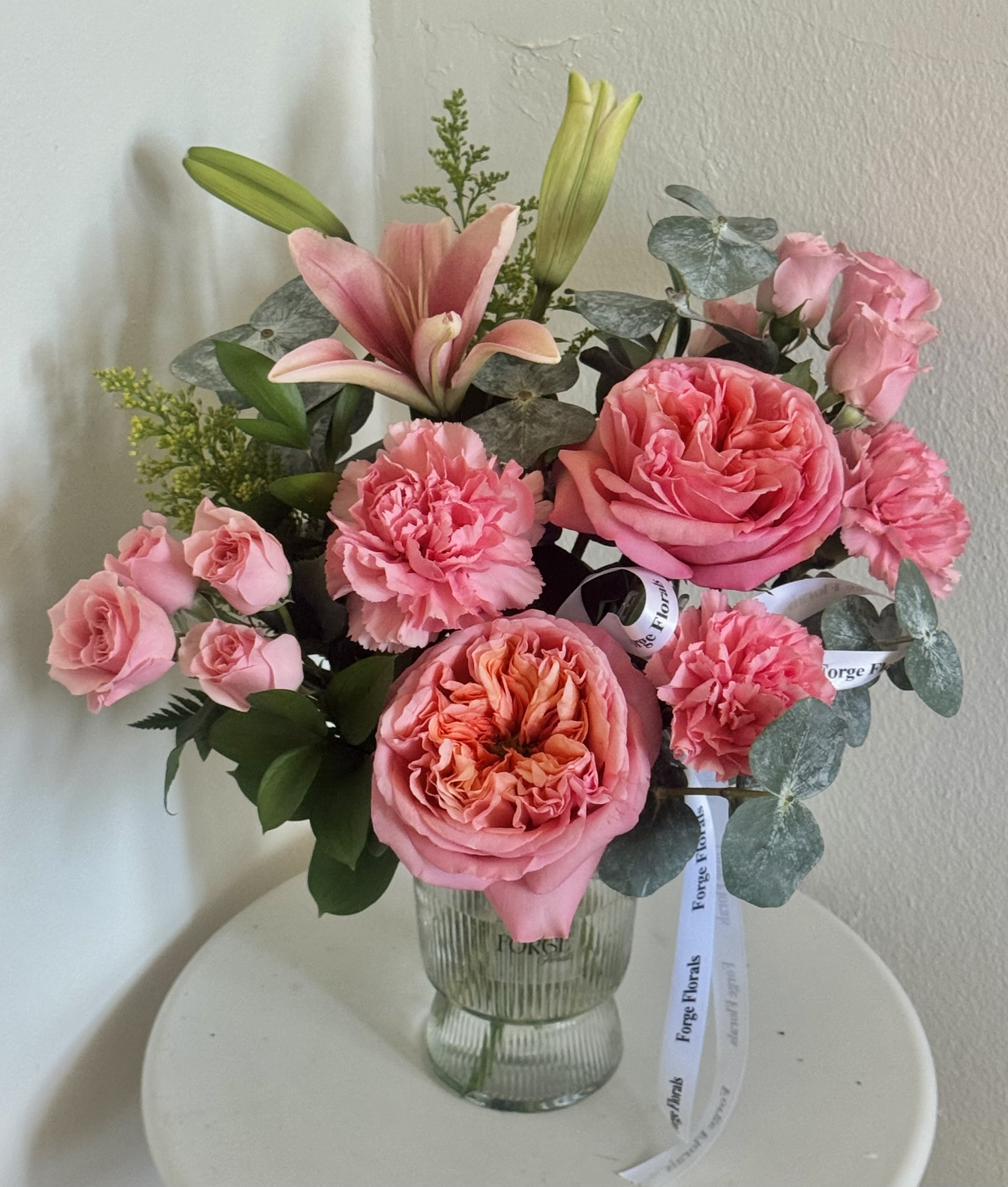 Day dream vase- garden rose,lily, mini roses - A lush garden-style arrangement featuring soft pink roses, spray roses, carnations and a fresh lily, accented with eucalyptus and seasonal greenery.
