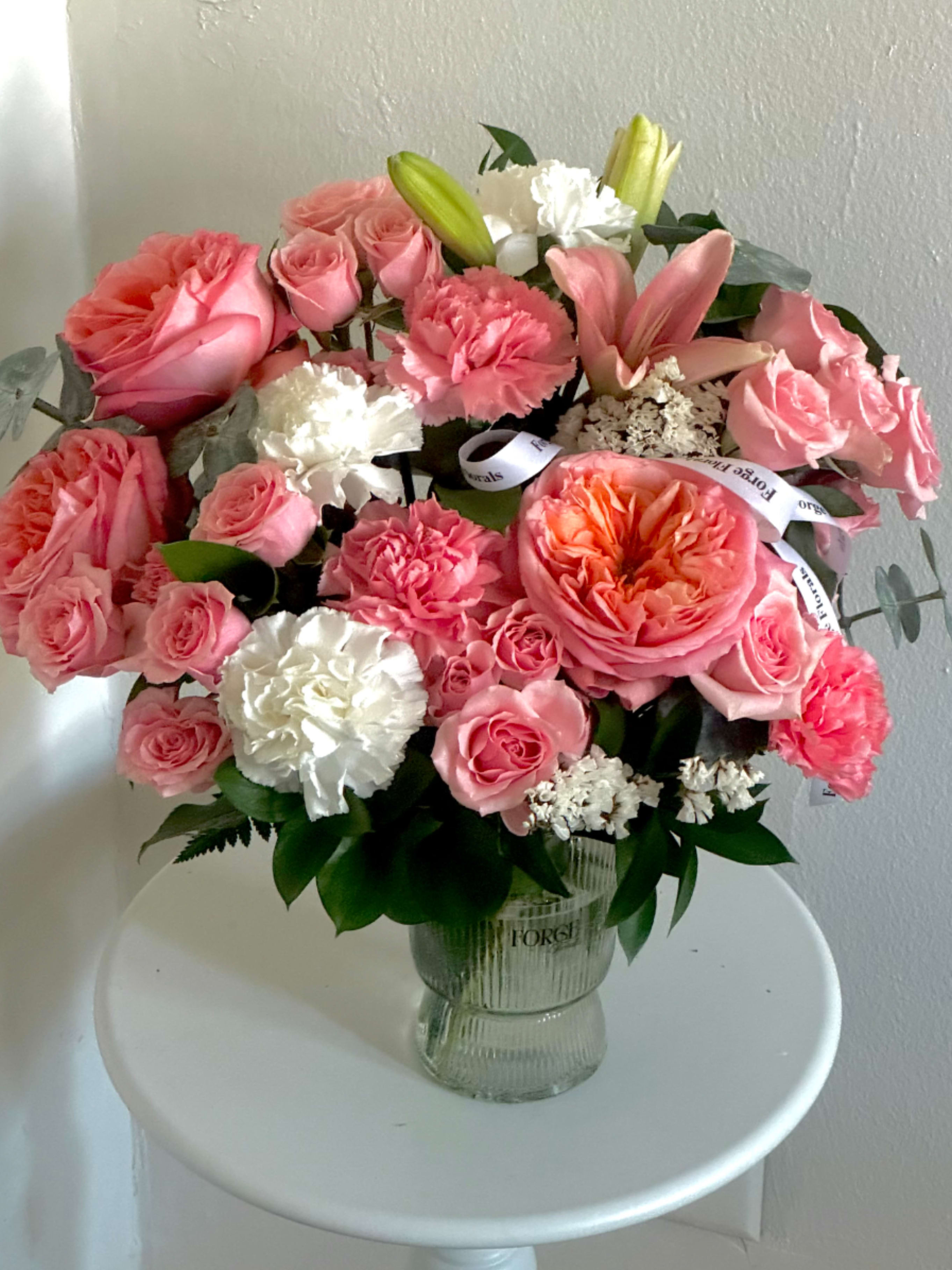 Cute Cindy vase- Lily, Garden roses,mini roses,eucalyptus, diantus - Vase arrangement with pink garden roses and Lilly. Vase is made out of plastic. 