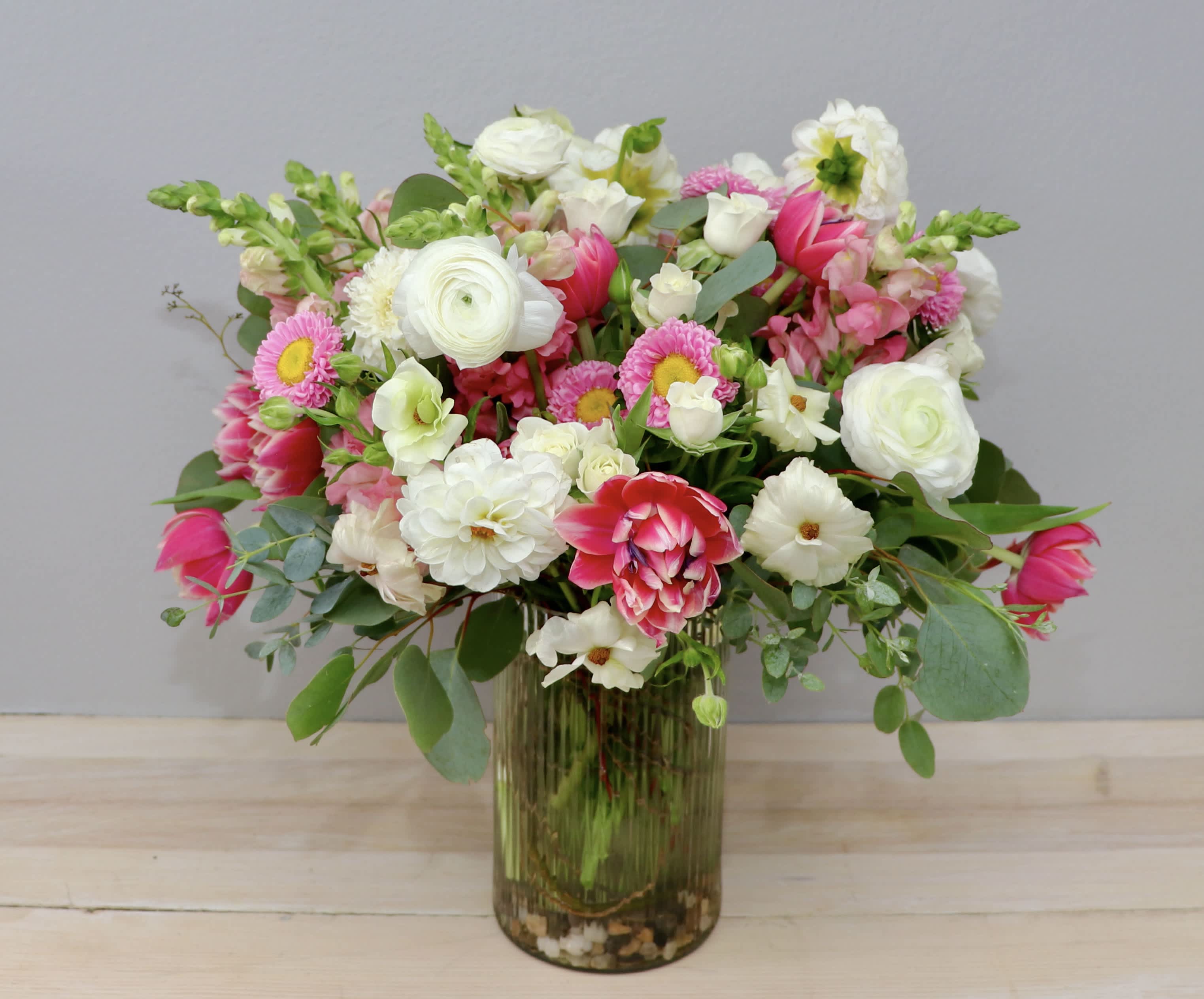 Mixed pink and white flowers arranged in a glass vase