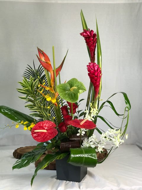 Tropical floral arrangement with red anthuriums and tall red ginger blooms