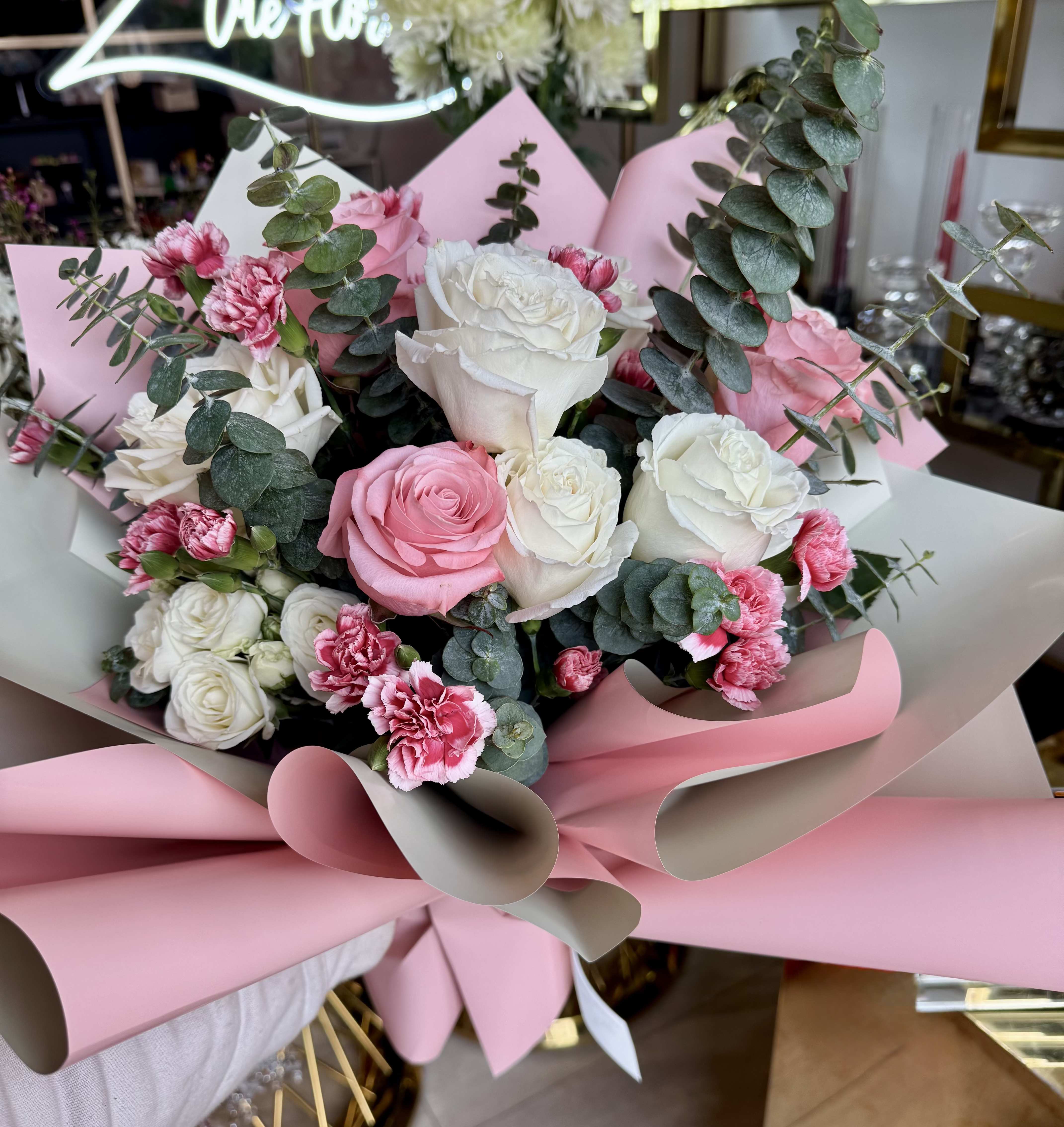 Pink and white rose bouquet with carnations and eucalyptus wrapping